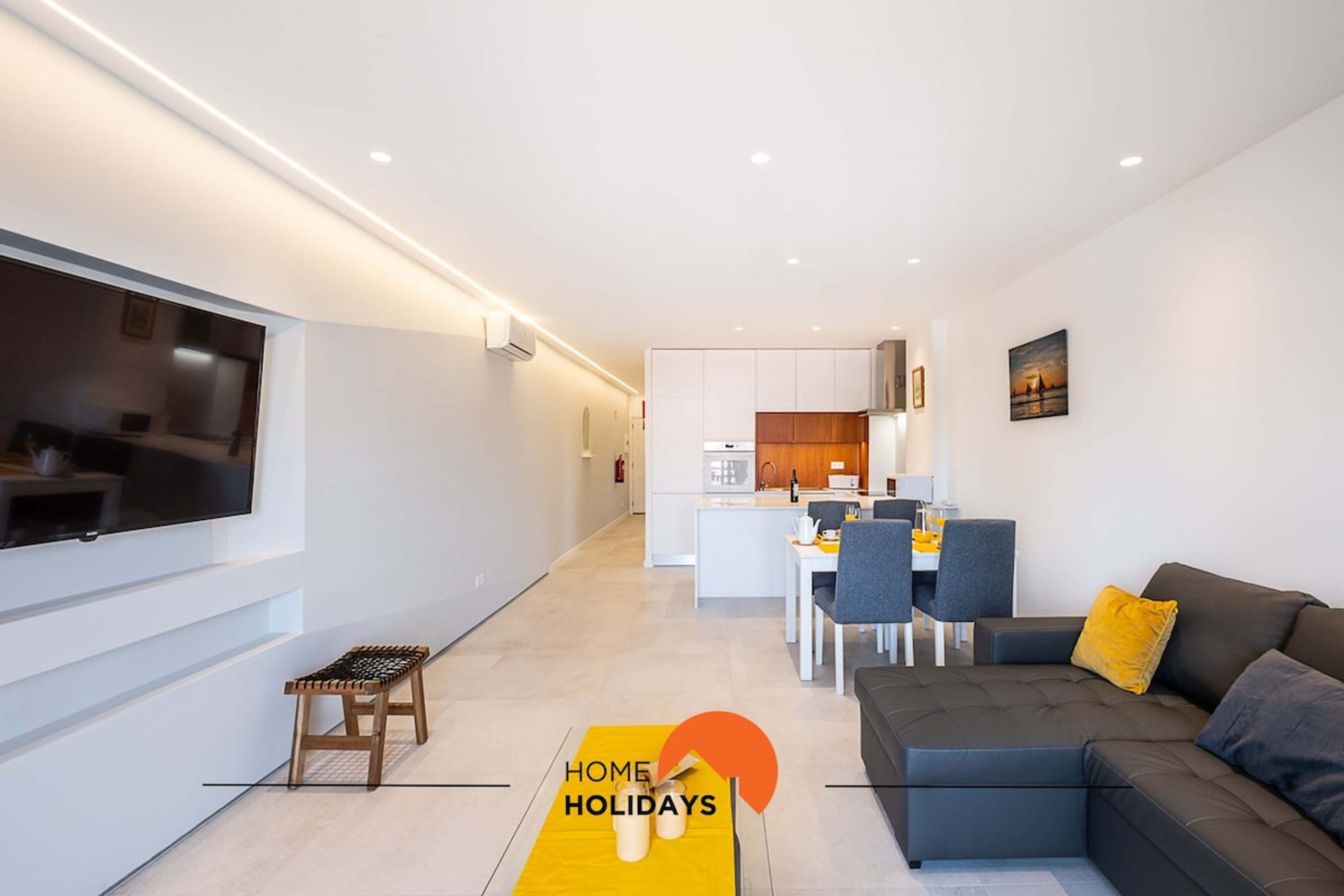 The large living room has a sofa, TV and dining area, with outdoor dining balcony.