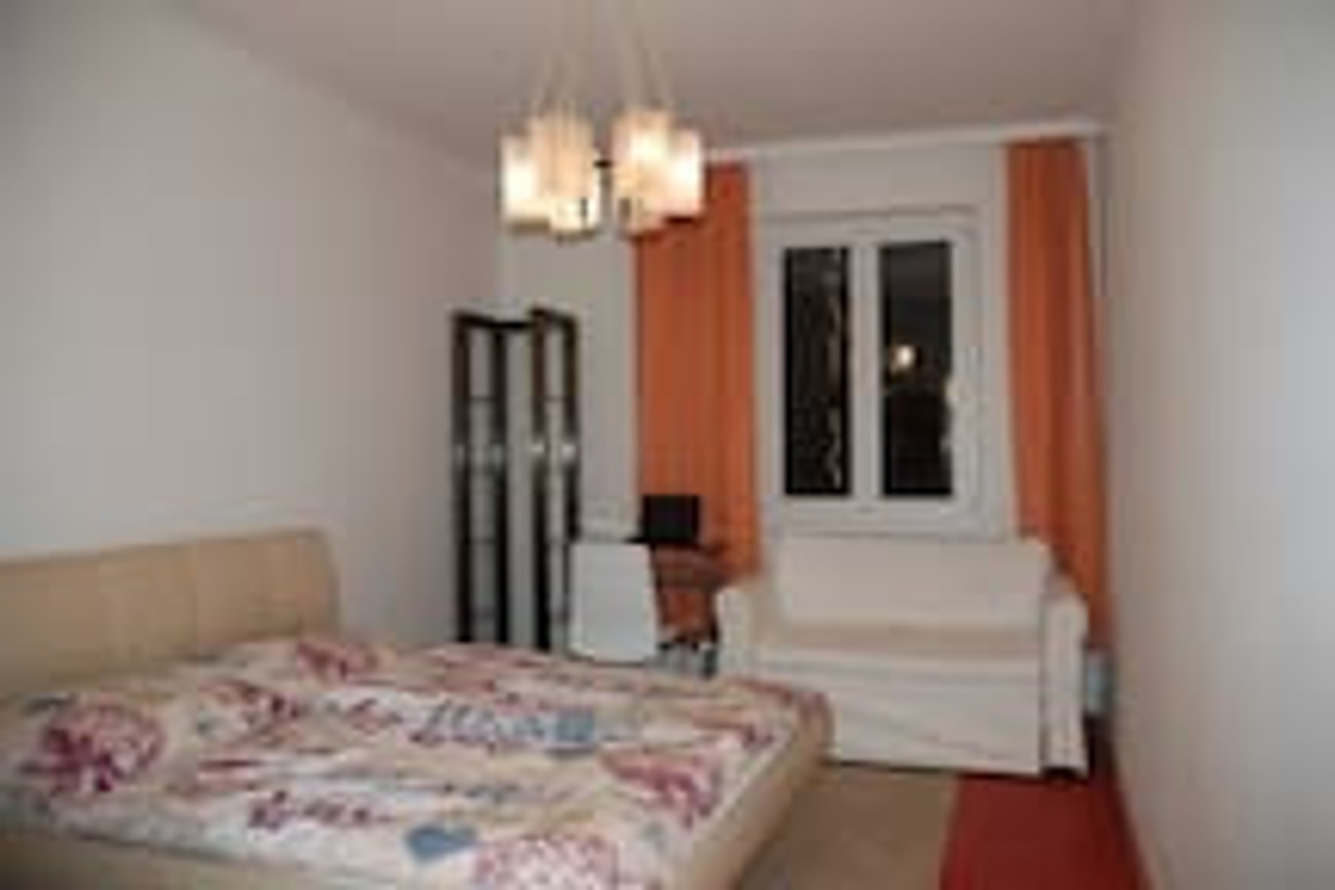 doublebed, white couch, small table with chair, bookshelf