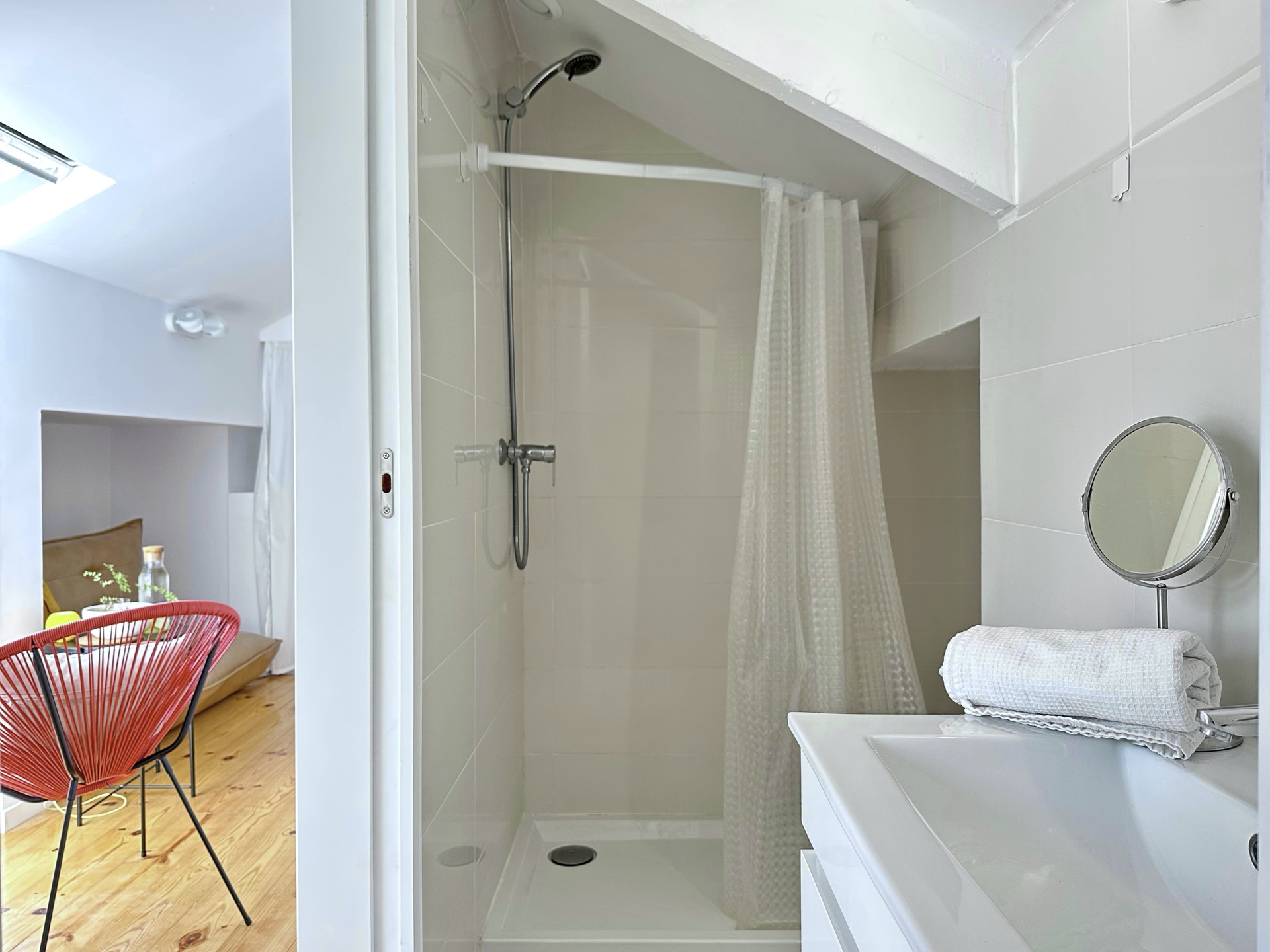 Bathroom shower with red chair view