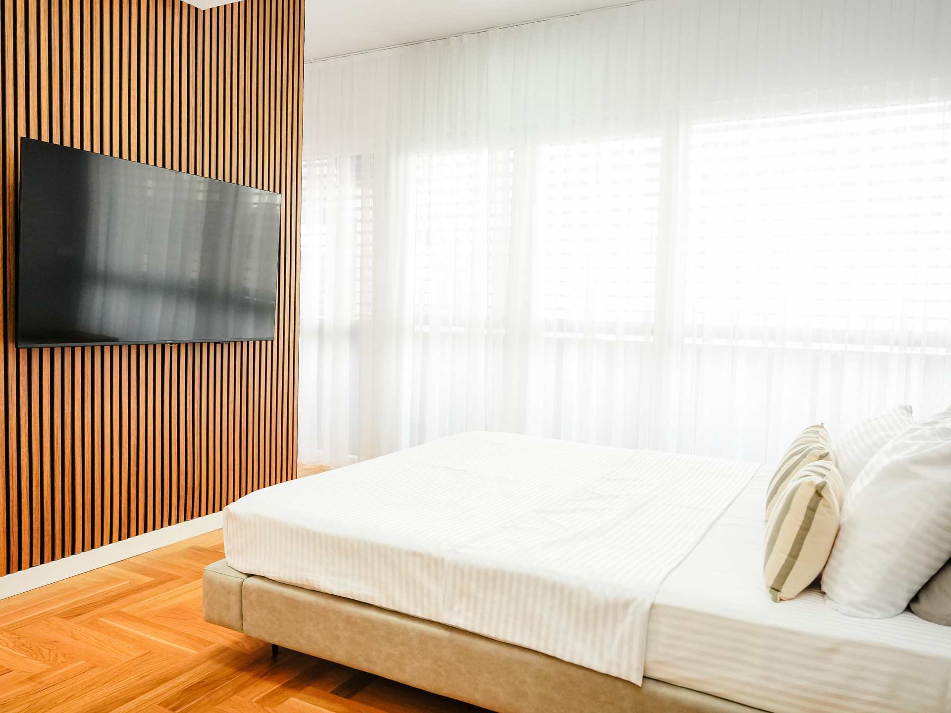 Bedroom with TV and wood wall