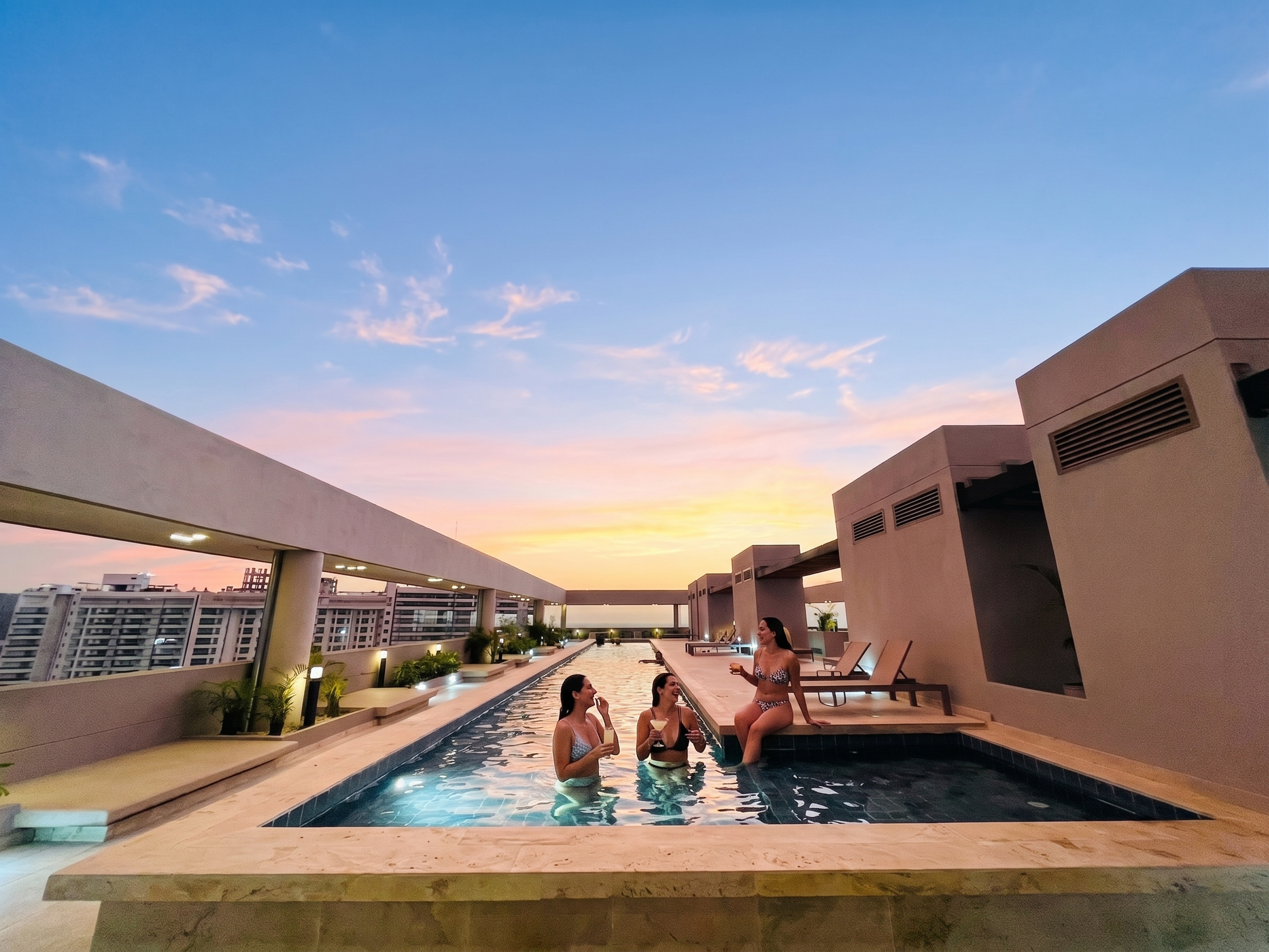 Piscina rooftop al atardecer con ambiente relajado y exclusivo