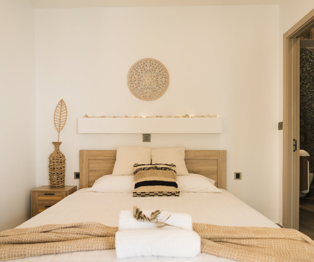 Bed with decor, bathroom door open