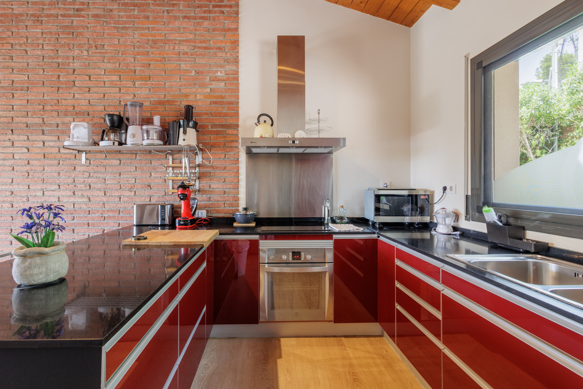 Red kitchen with brick wall