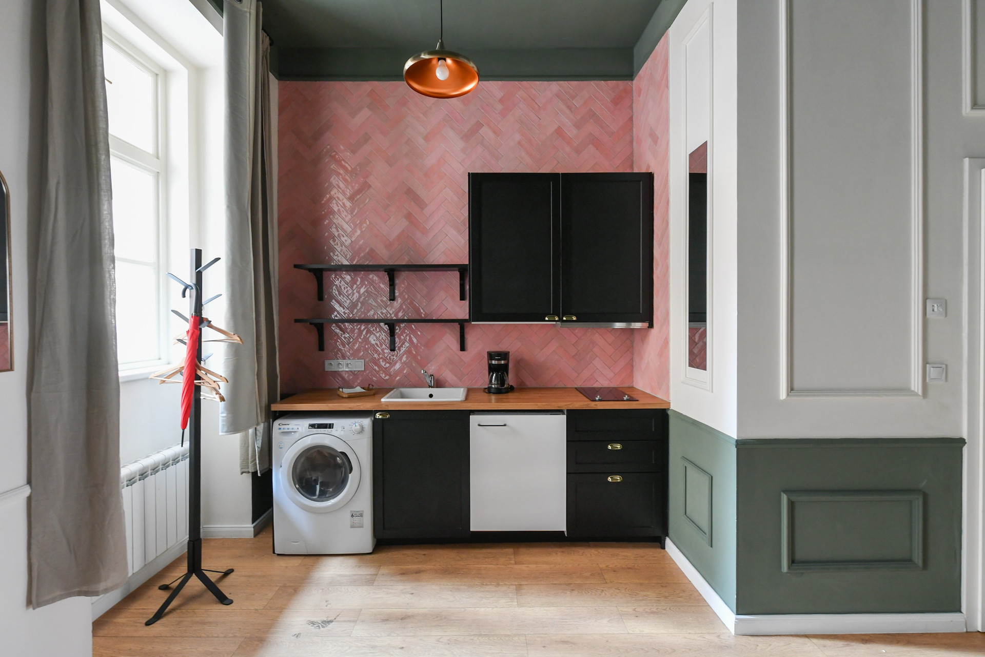 Kitchenette with pink tiles, washer
