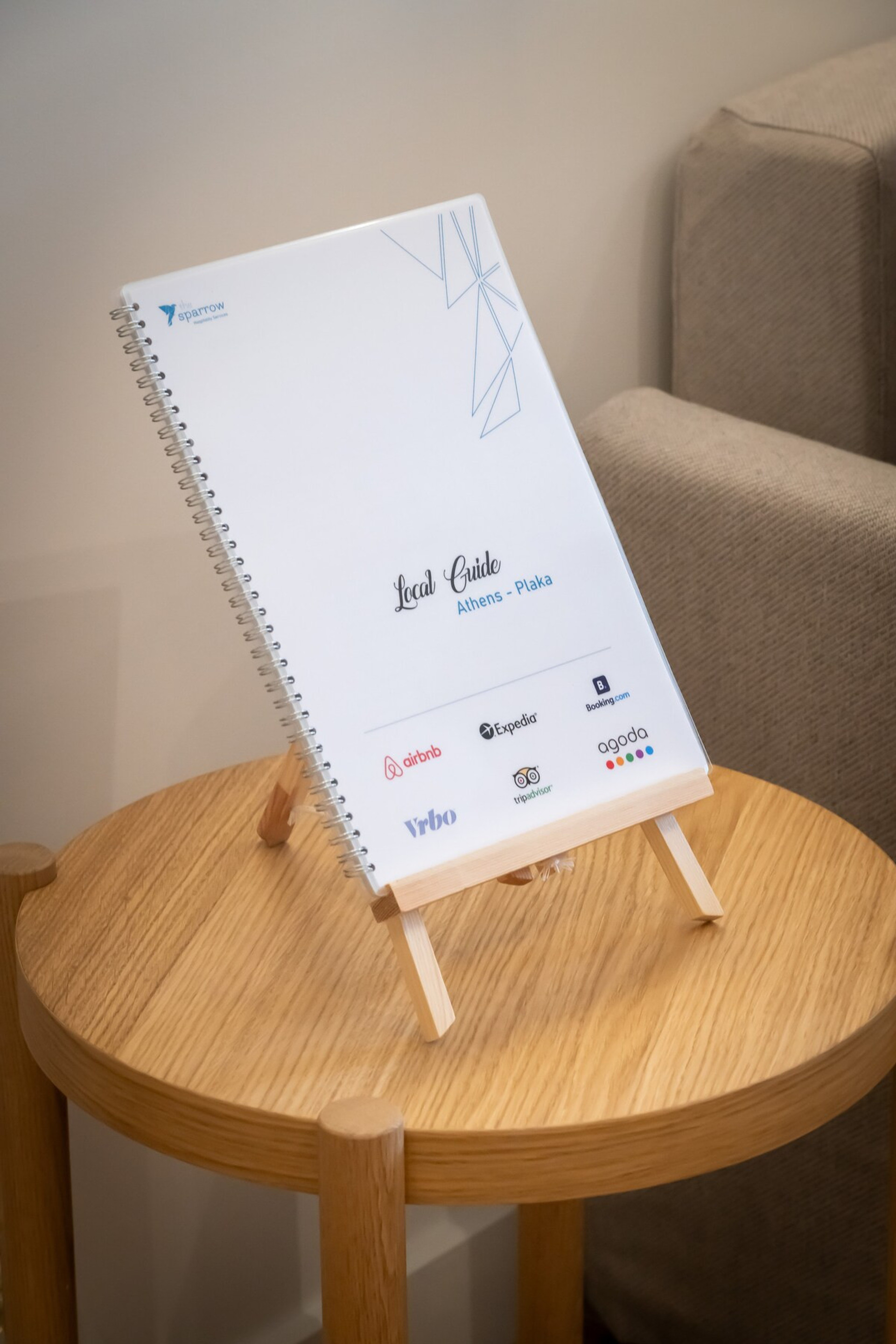 A cosy touch awaits with a thoughtfully placed local guide on a chic wooden table beside a comfy sofa. Perfect for planning your adventures while relaxing in style.