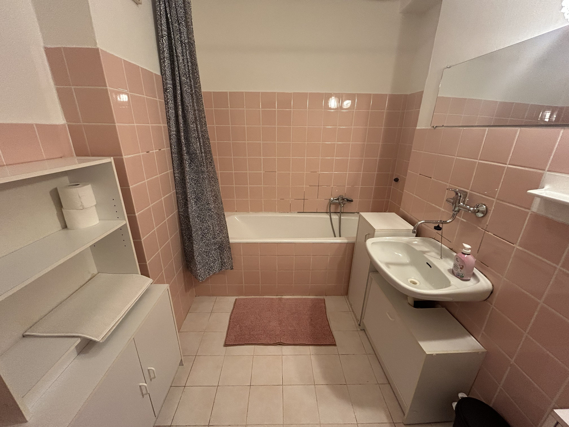 Pink tiled bathroom with bathtub