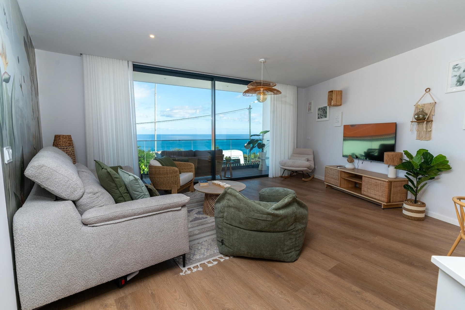 Bright and modern living room with sea view and natural decor. Comfortable sofa and large balcony ideal for relaxing.
