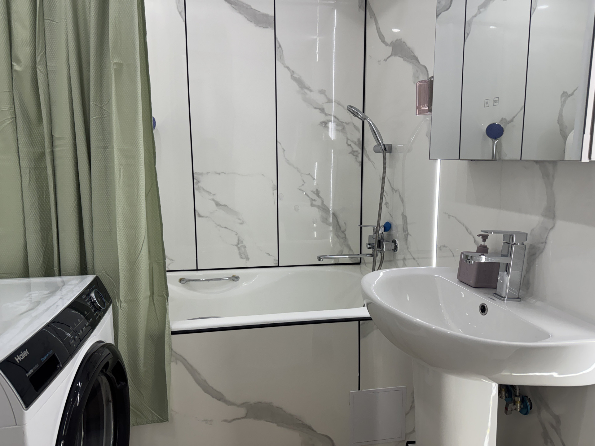 Bathroom with tub and washer