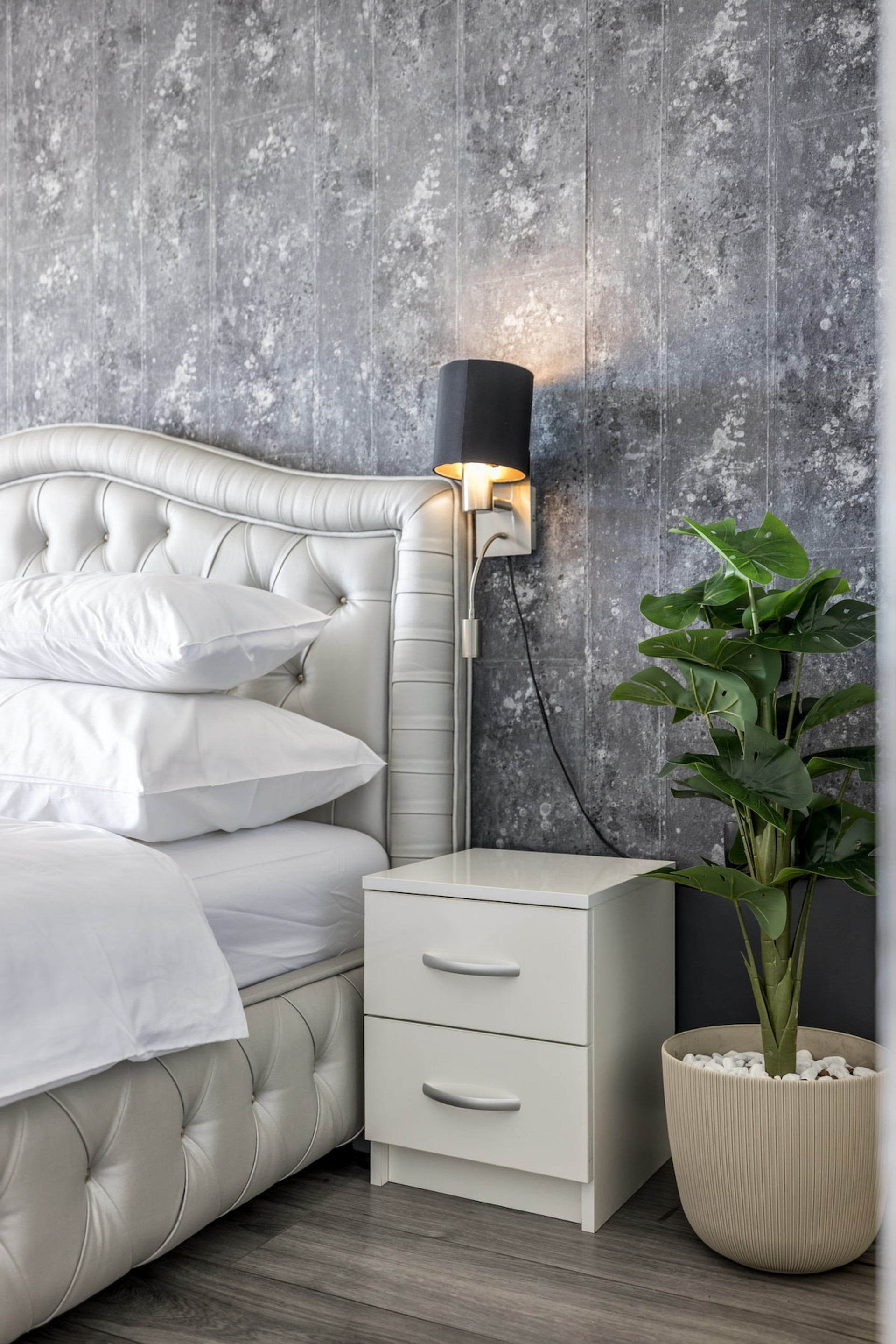 A cozy bedroom corner with a nightstand and a lamp.