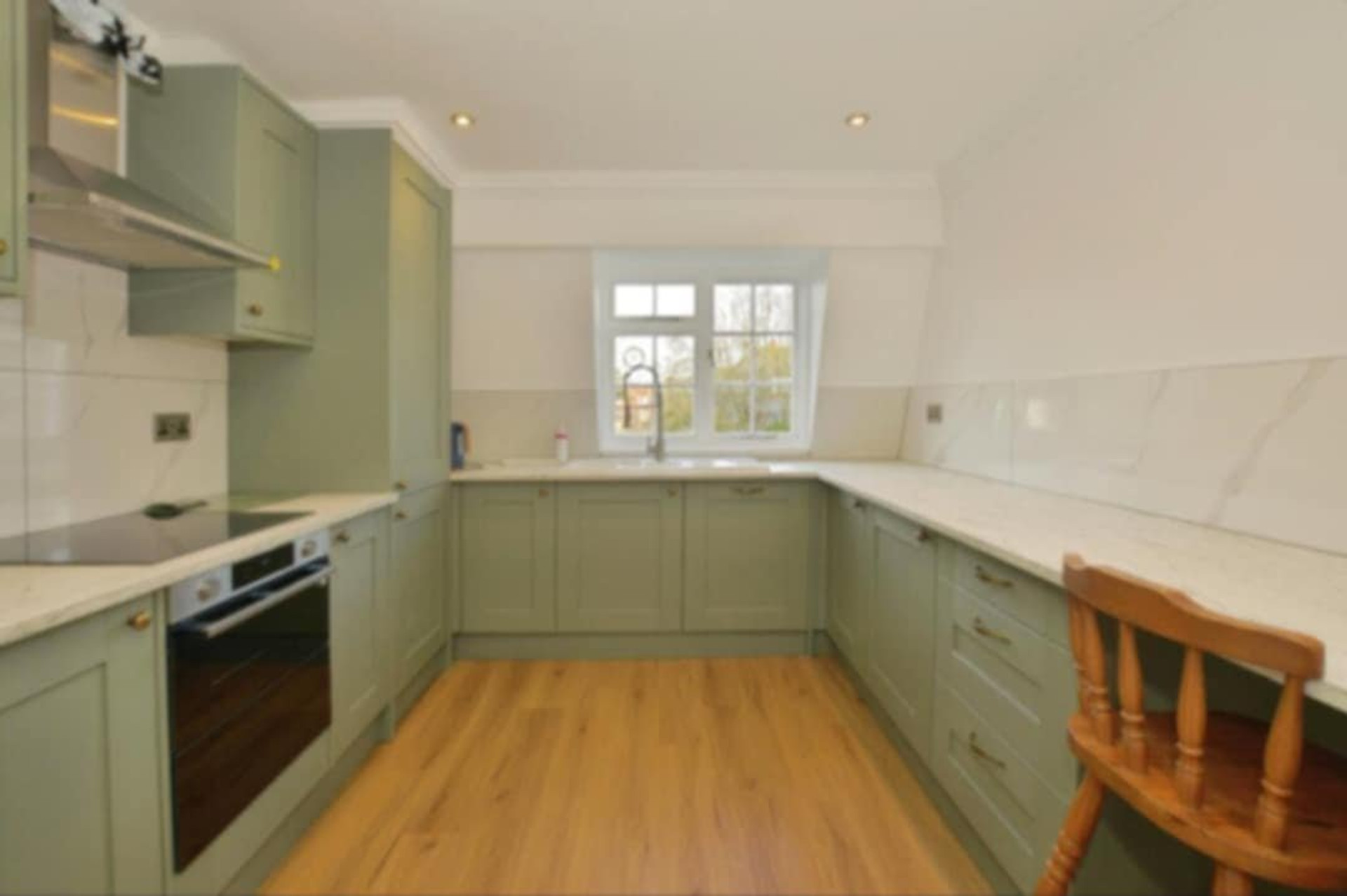 Green kitchen with oven and window