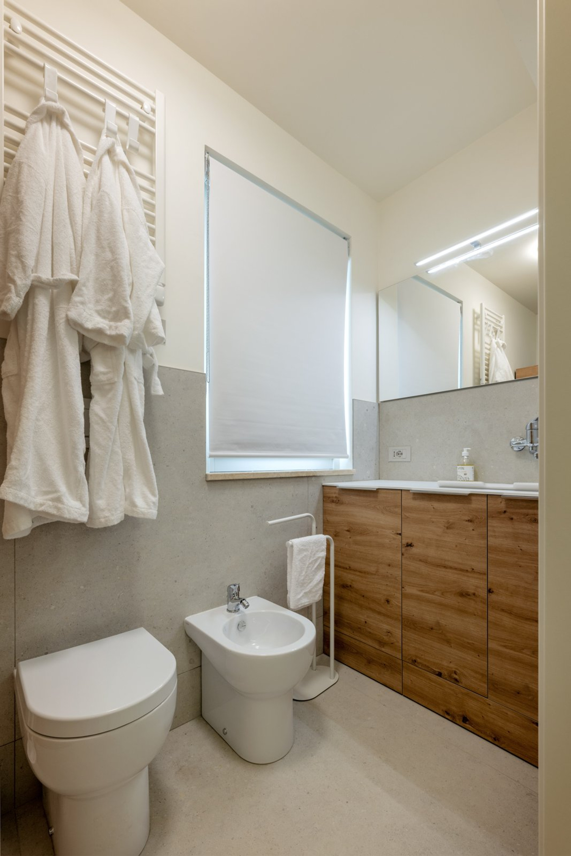 Bathroom with wooden vanity and robes