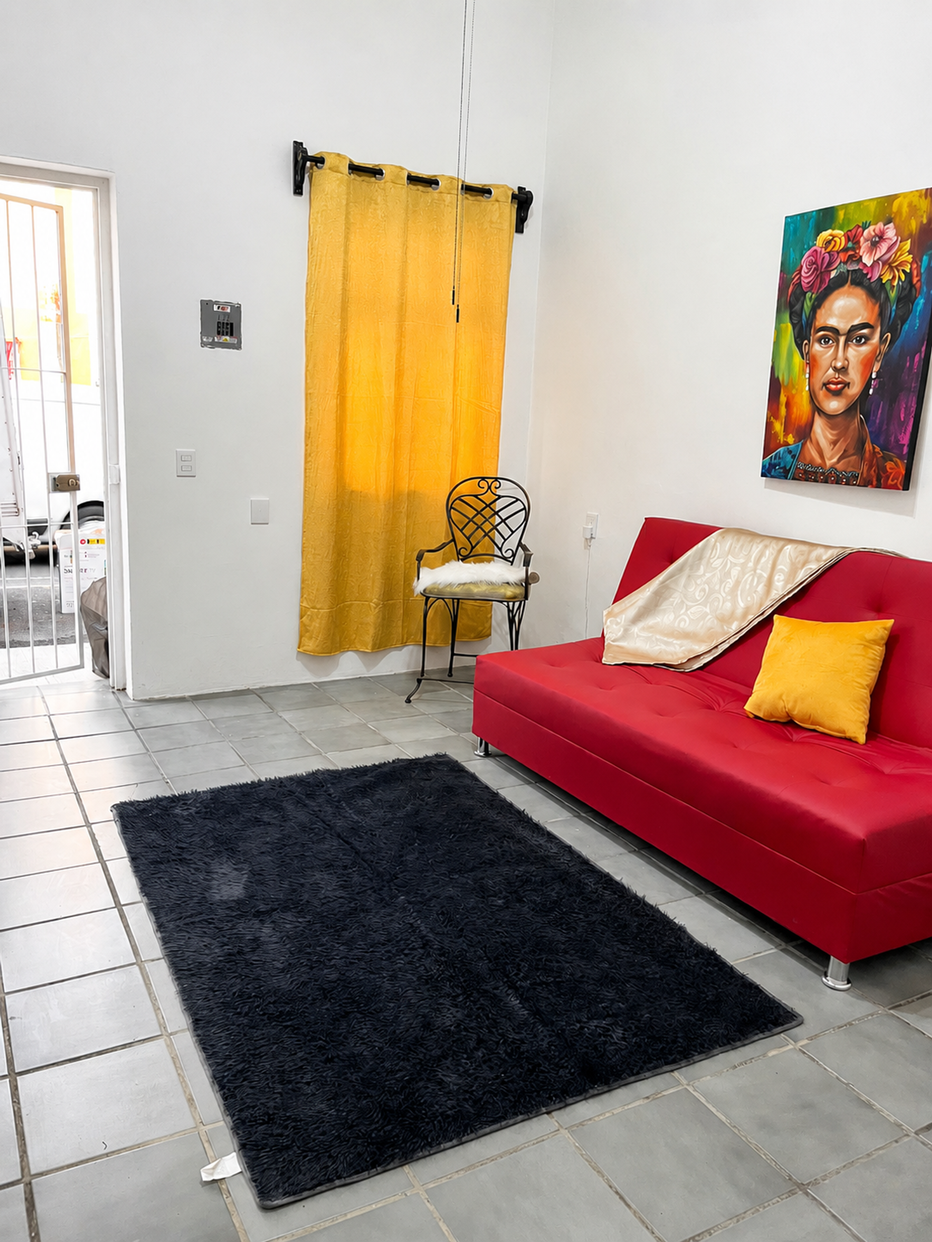 Spacious and bright living room with a double sofa bed, Mexican-style décor, and access to the inner patio. Sala amplia y luminosa con sofá cama matrimonial, decoración mexicana y acceso hacia el patio interior.