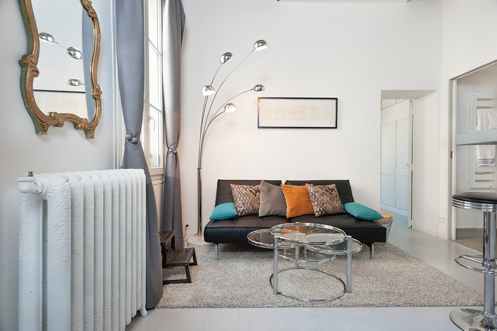 A beautifully lit, contemporary living room featuring charming exposed wooden beams and high ceilings.