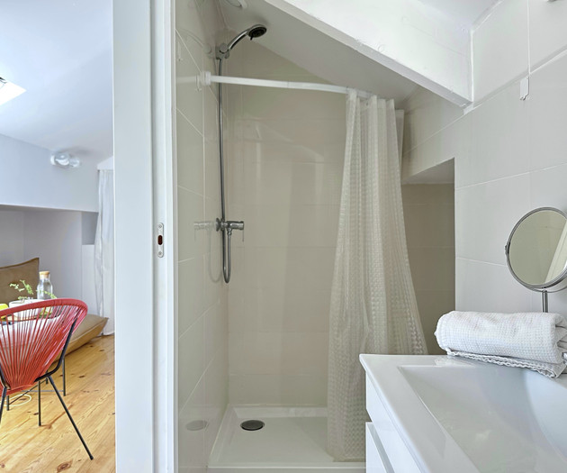 Bathroom shower with red chair view