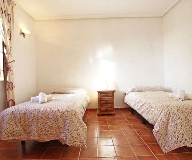 Twin bedroom with terracotta floors