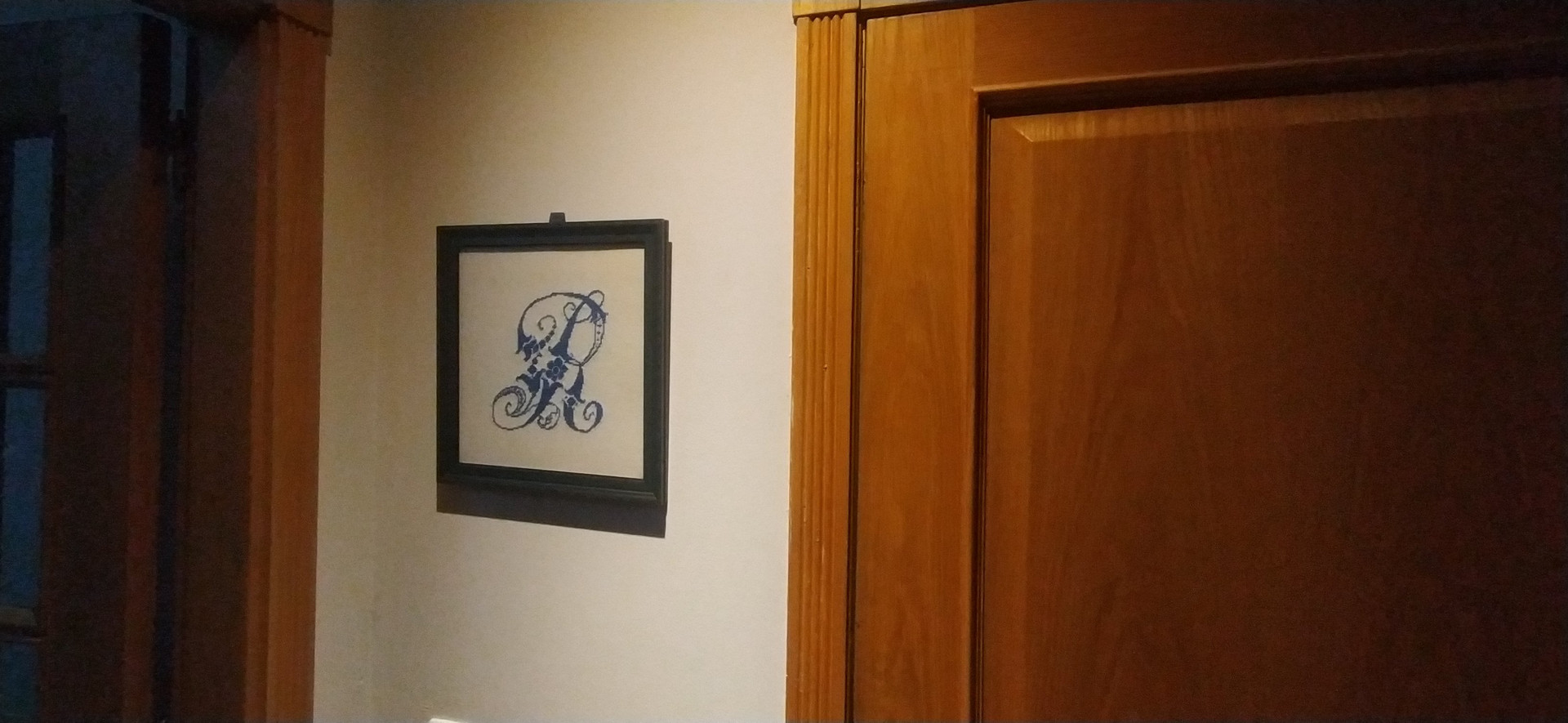 Hallway with framed monogram and door