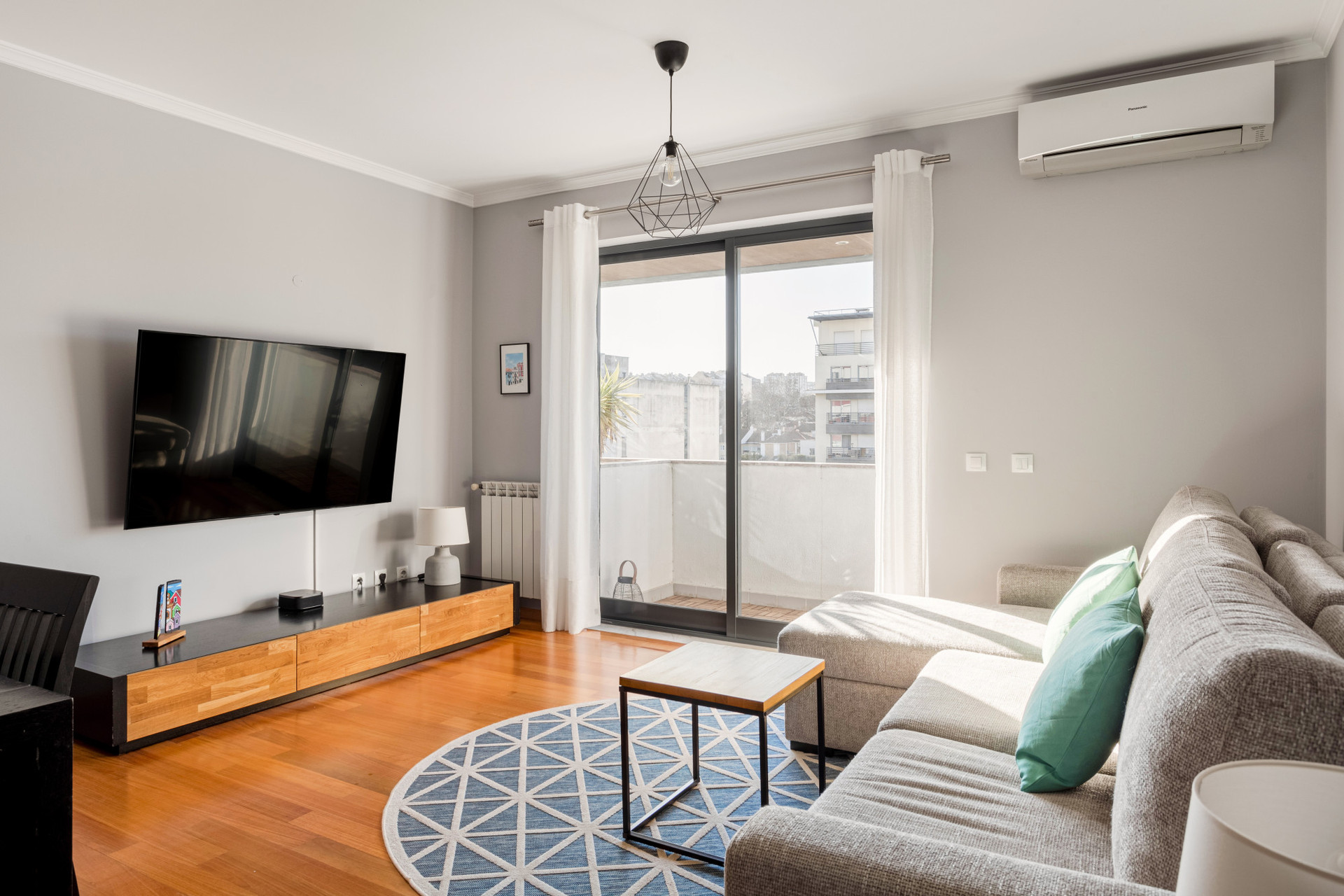 A spacious, light-filled area featuring a comfy chaise-longue sofa, a dining table for four, and a TV for relaxing evenings