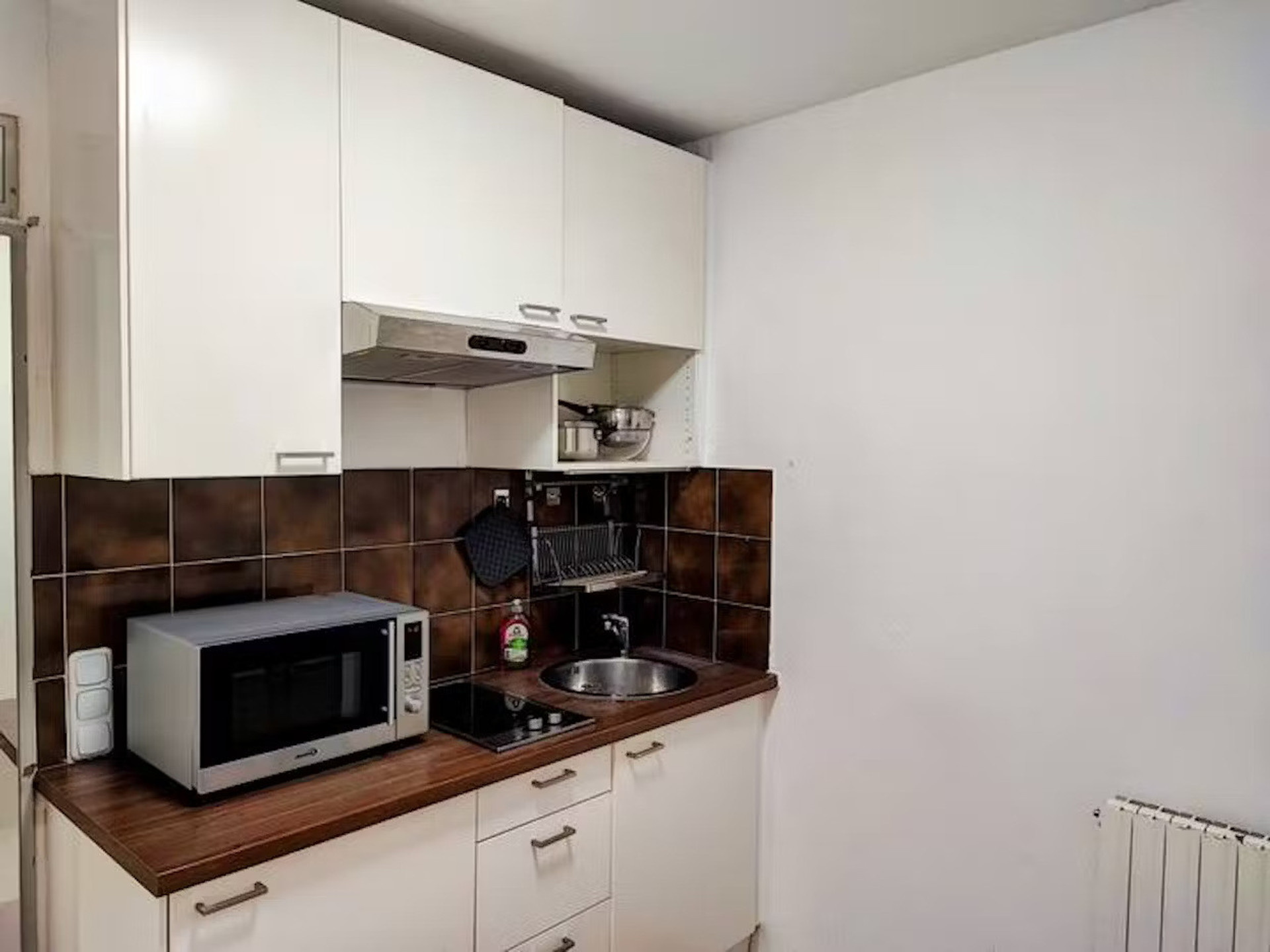 Compact white kitchen with microwave