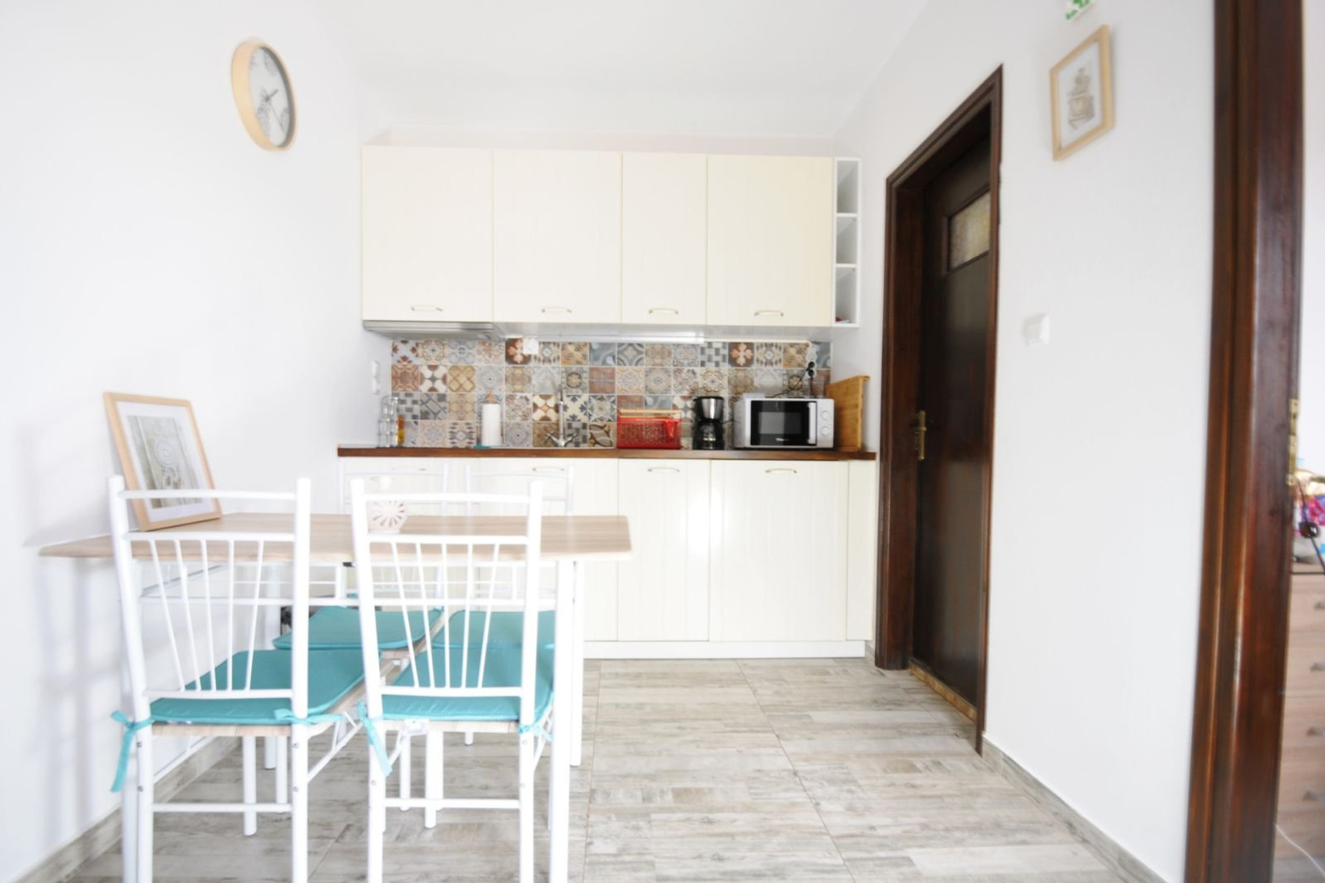 A bright and modern kitchen-dining area featuring a fully equipped workspace, stylish cabinetry, and a cozy dining corner, ideal for comfortable everyday living.