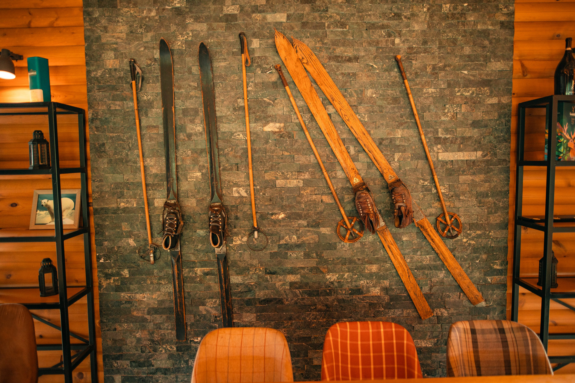 Beautiful vintage skis and poles displayed on a stone wall, adding authentic mountain character and cozy alpine atmosphere to the common area.