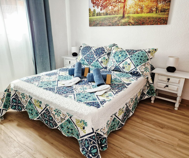 Bedroom with decorative bedspread and towels