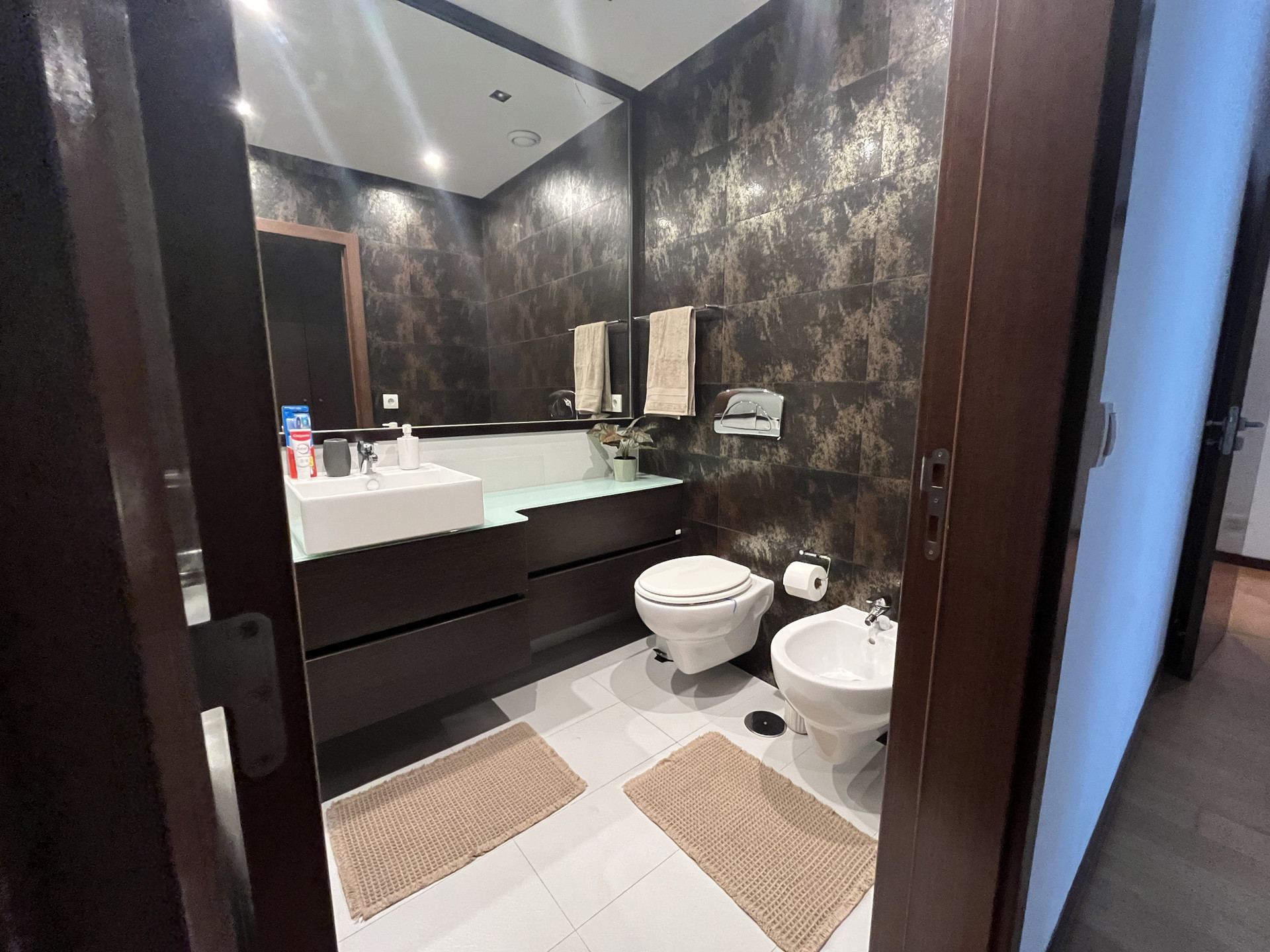 Dark tiled bathroom with bidet