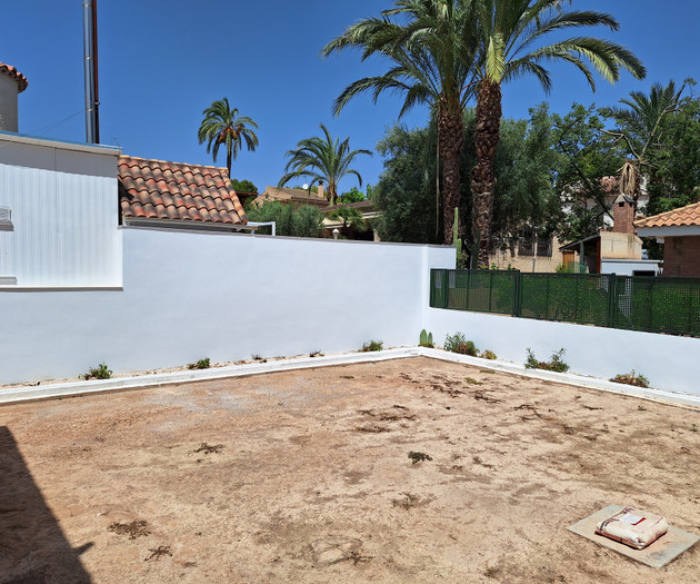 Empty backyard lot with wall