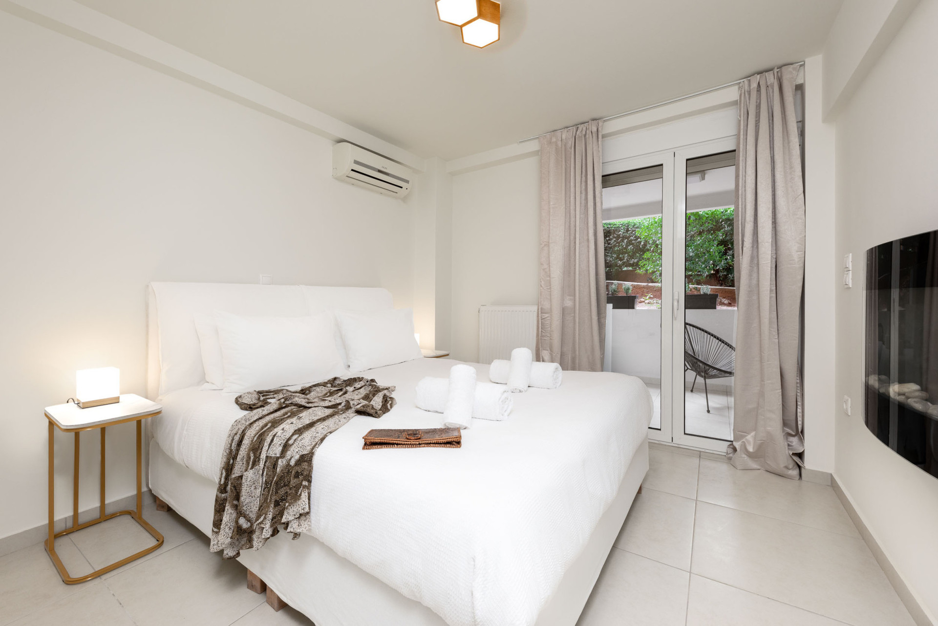 Bedroom with large bed and electric fireplace.