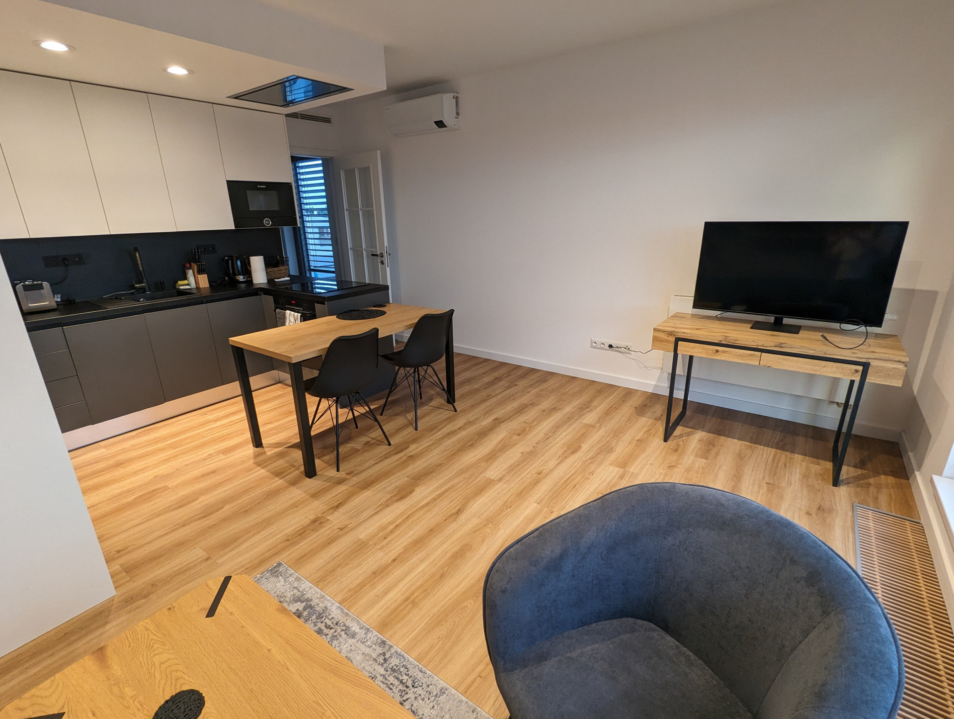 Picture of the desk in the living room with a huge smart monitor which doubles as a tv