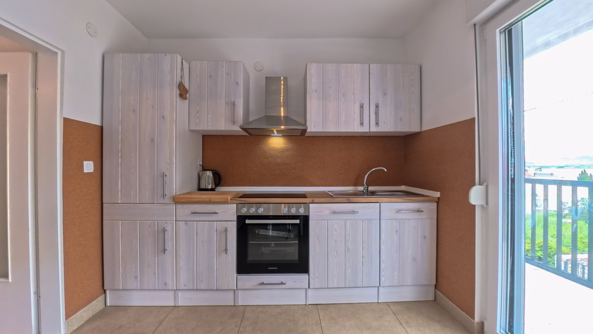 Kitchen with oven and balcony access