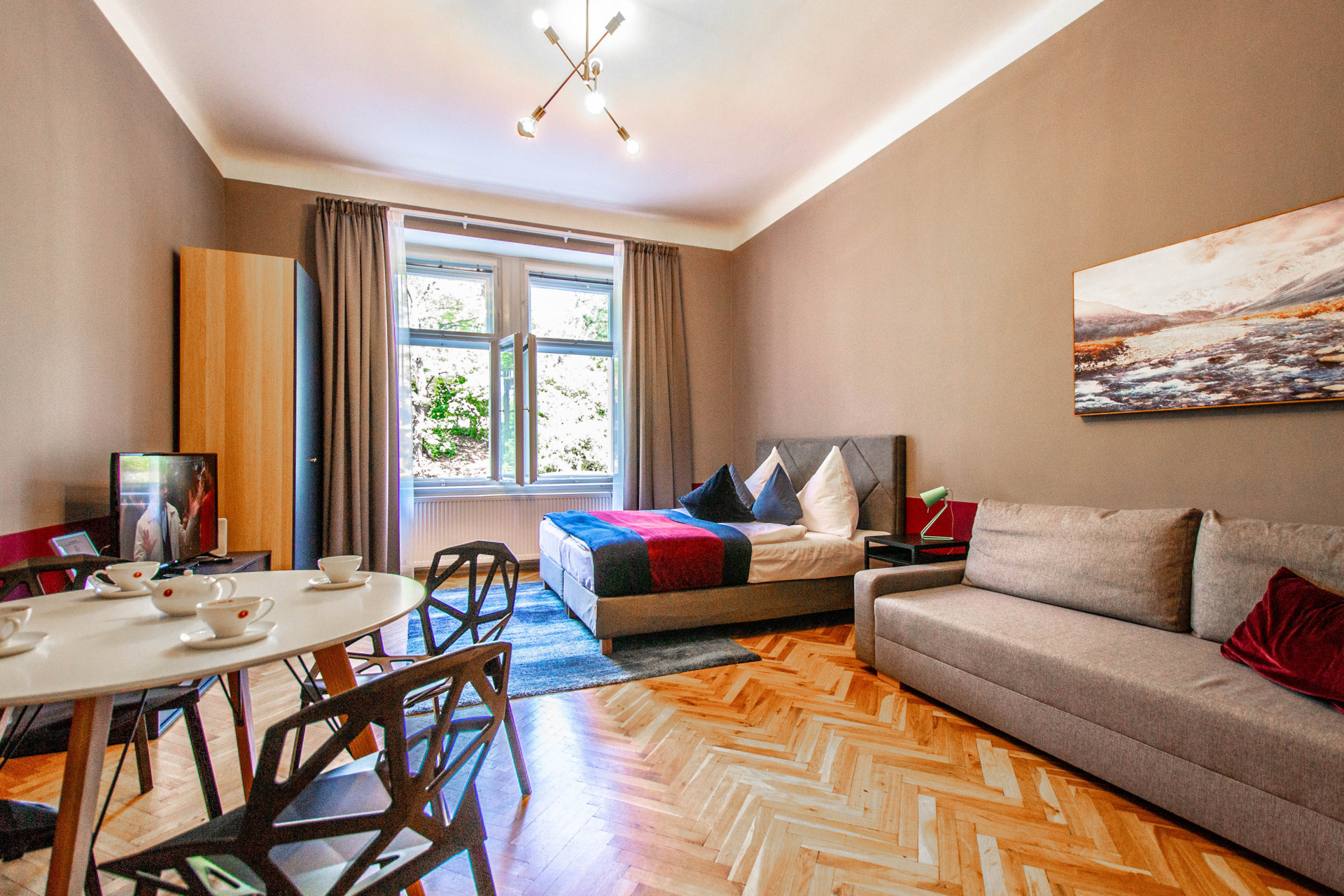 Comfortable bed, design chairs, and convertible sofa
