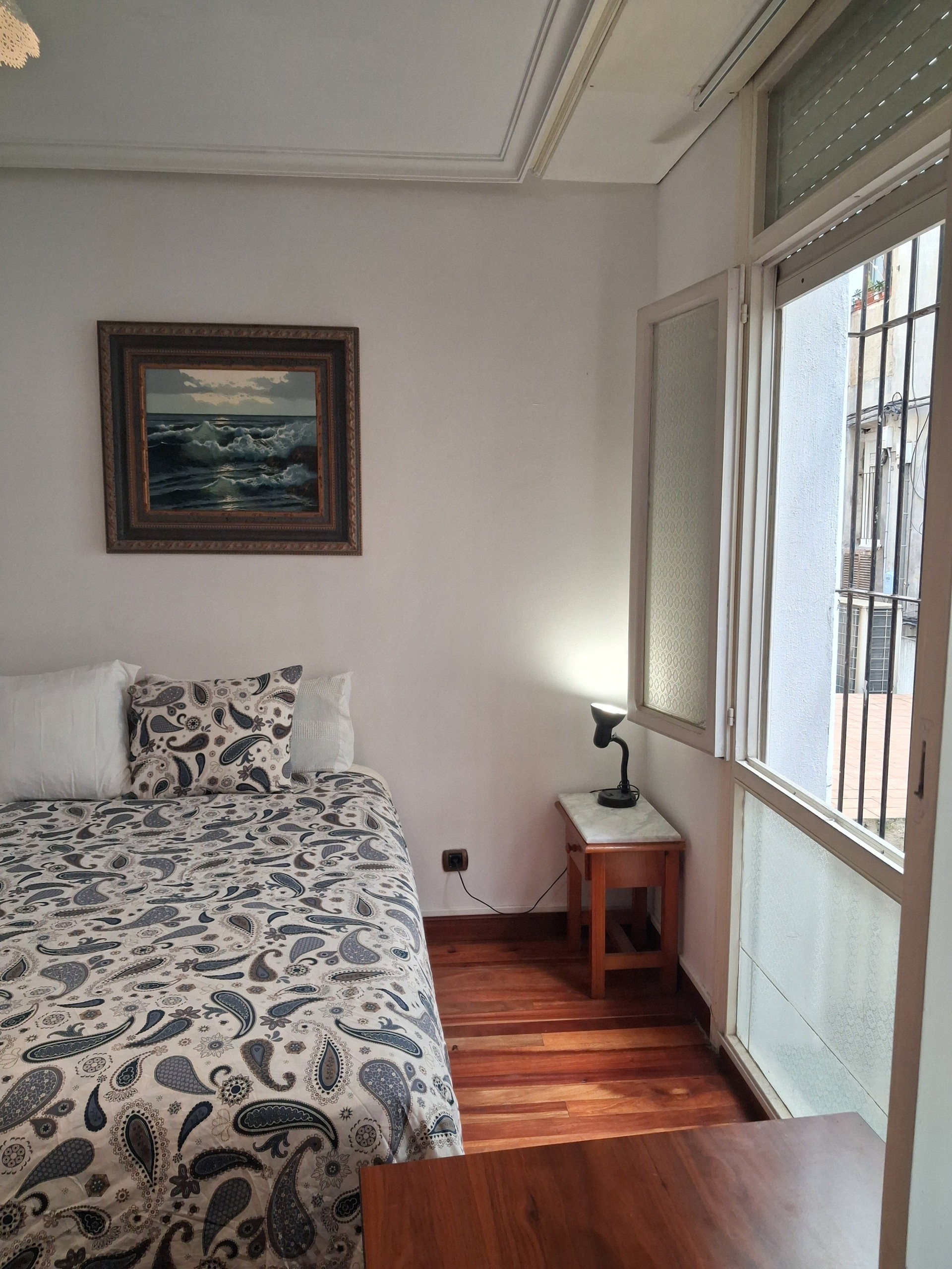 Bed beside window with nightstand