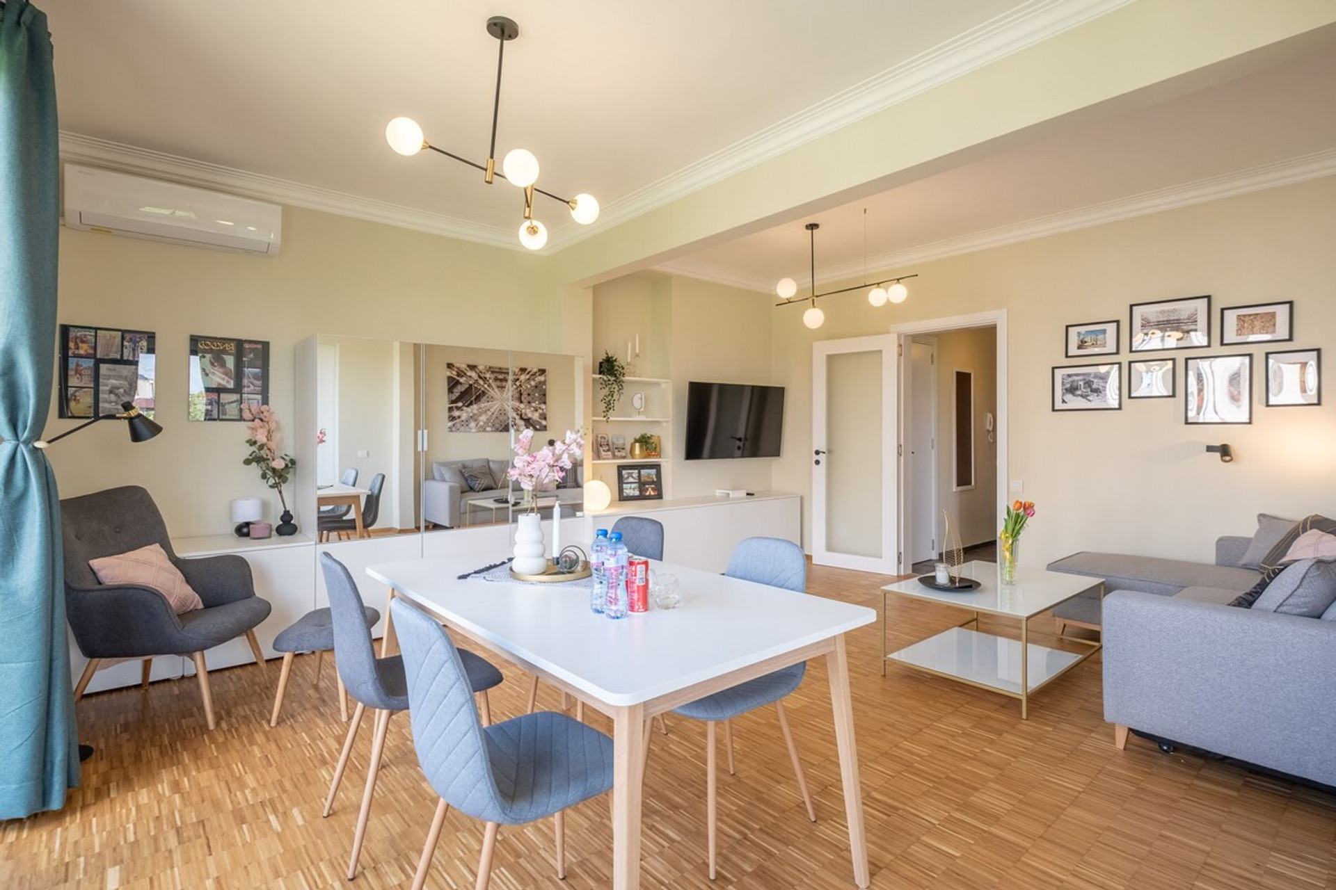 Bright and stylish combined living and dining area, featuring comfortable seating, modern decor, and a dining table for four. The perfect setting to relax, dine, or enjoy a peaceful moment with natural light streaming in.