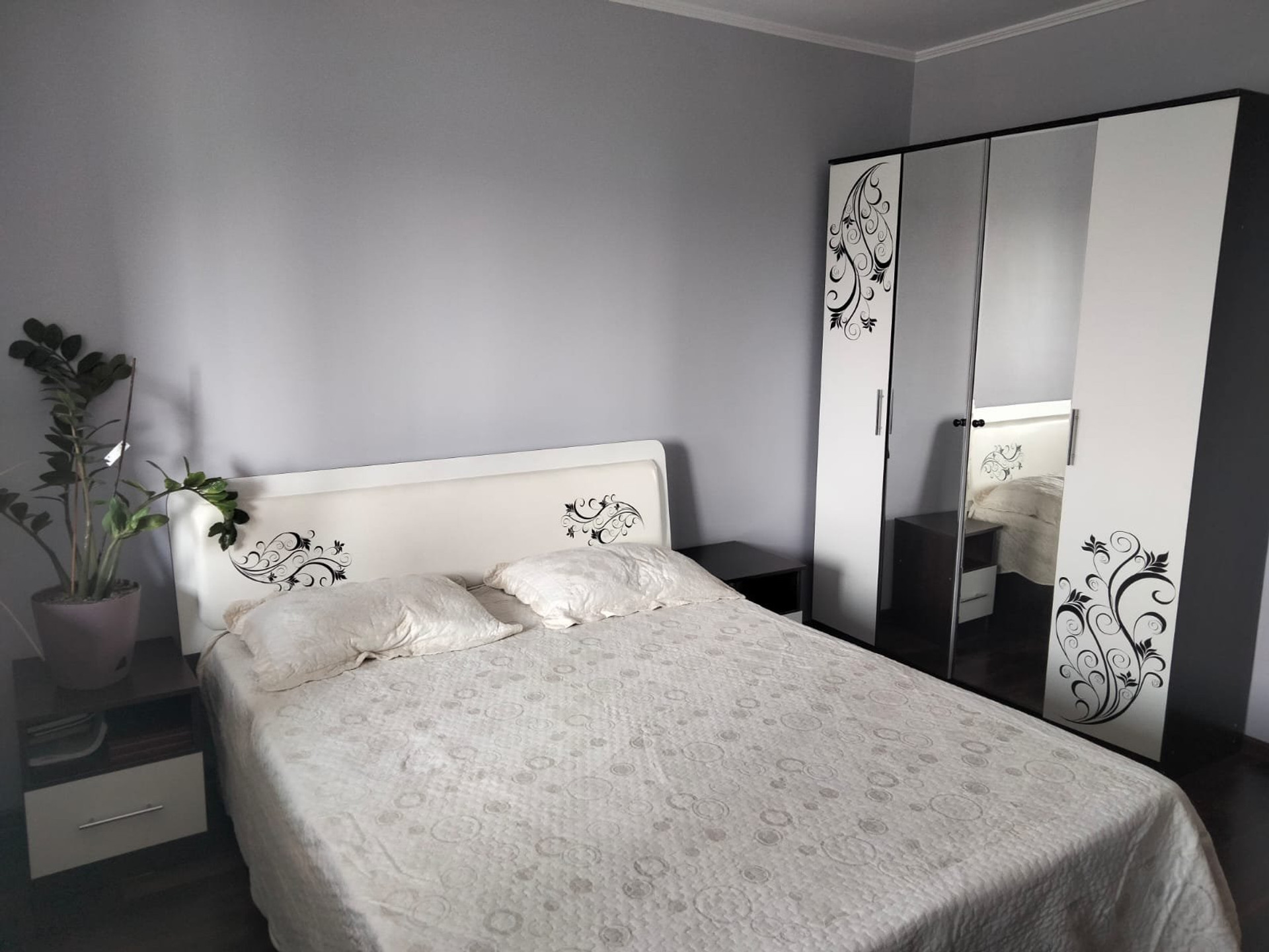 Cozy bedroom with a comfortable double bed, spacious wardrobe and soft natural lighting.