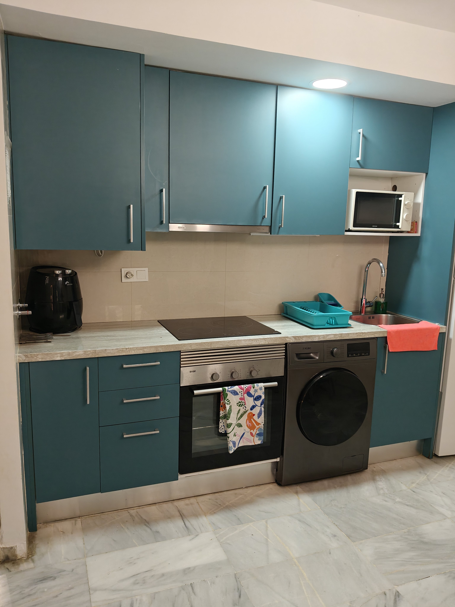 Teal kitchen with washing machine