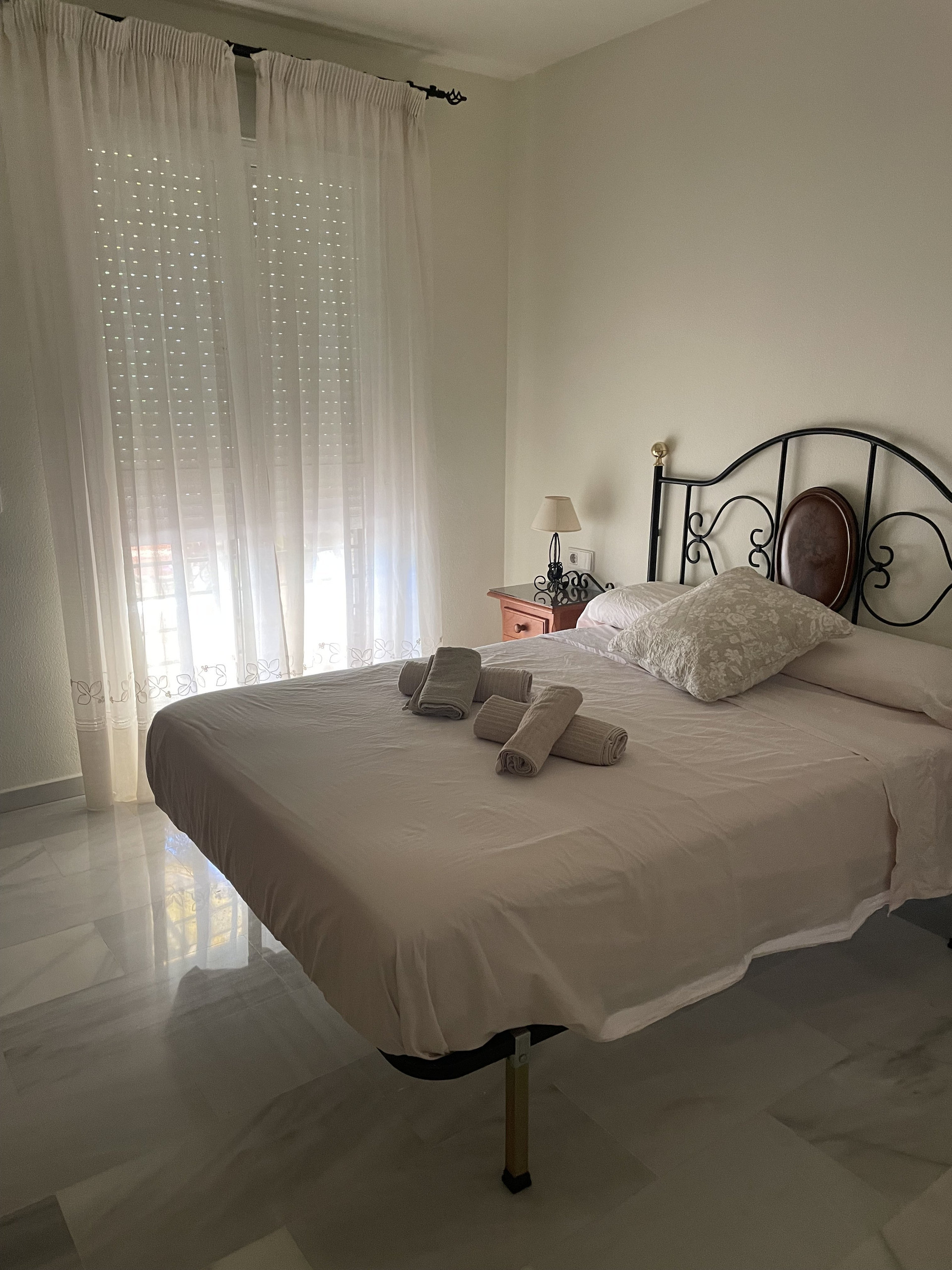 Bedroom with rolled towels on bed