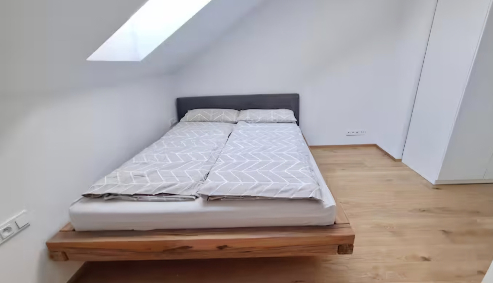 Bedroom with platform bed under skylight