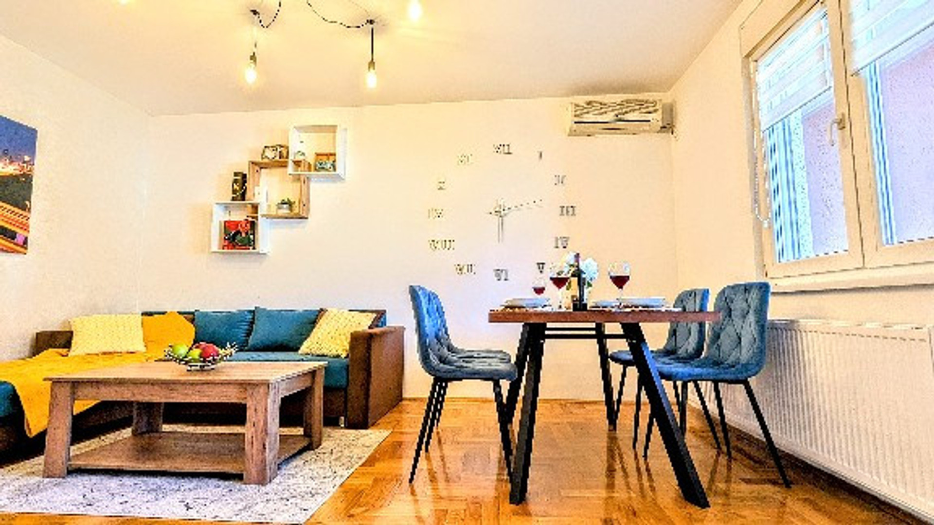 The living room is as spacious and bright as you can see in the picture. It is equipped with comfortable turquoise-green pull-out furniture, paintings, details that open up the space, a soft carpet, a table for storing things, a 35-inch plasma HD TV