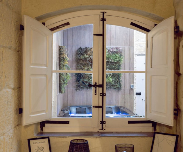 Interior window overlooking courtyard hot tub