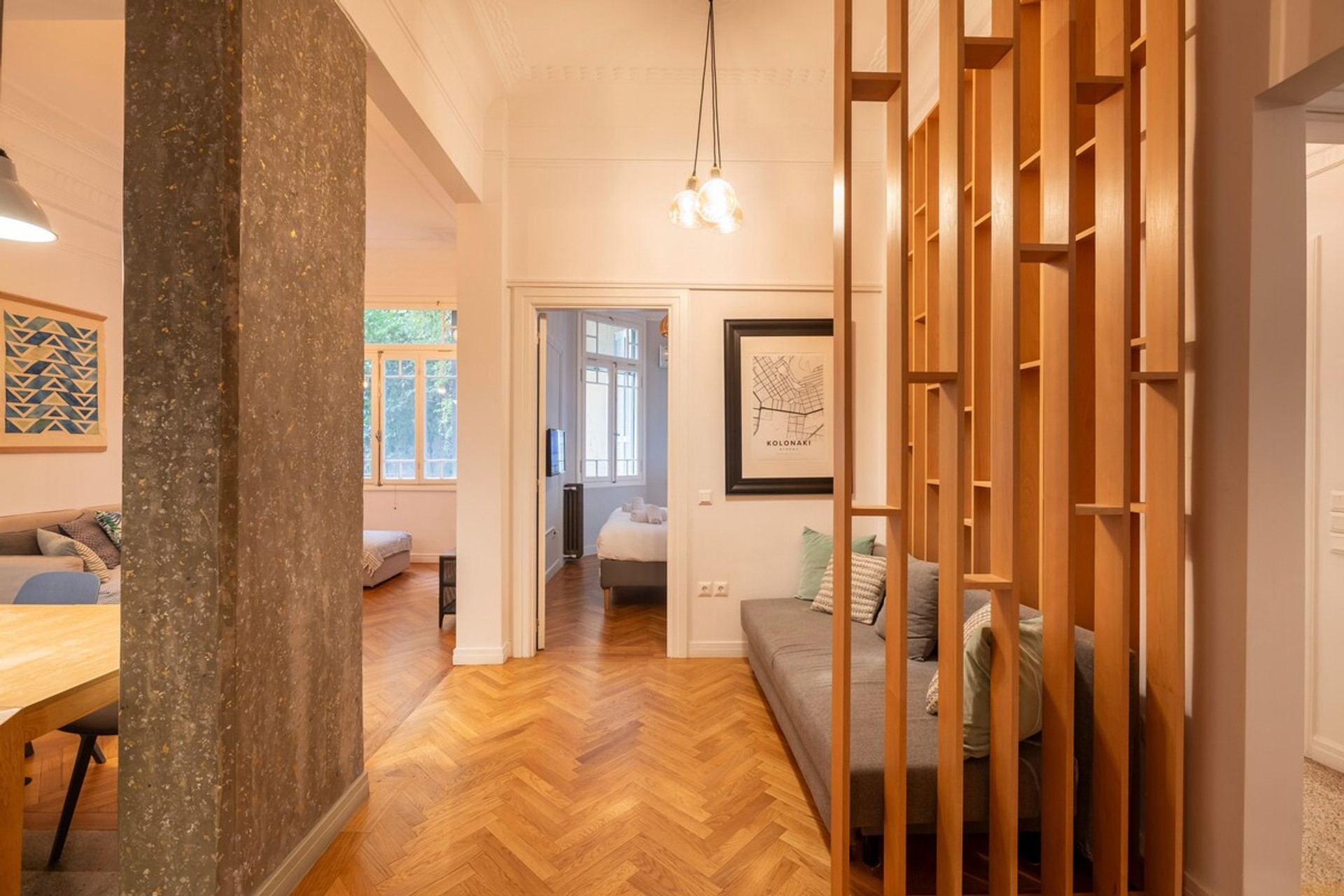 A beautifully designed space with warm wooden floors, elegant lighting, and a stylish partition that adds charm. The cosy seating and inviting layout make it perfect for relaxation or socialising, with natural light flowing through the rooms.