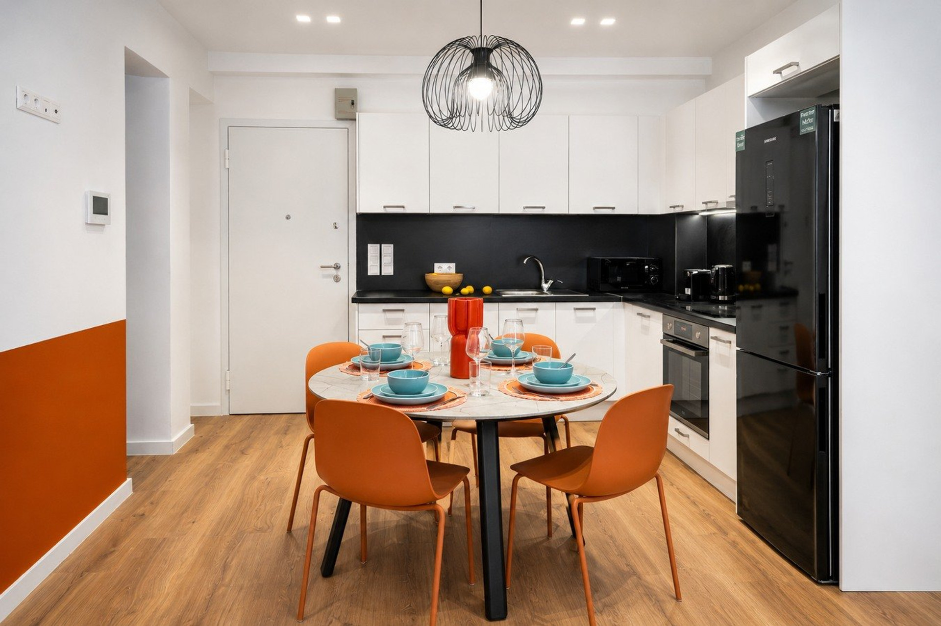 Kitchen and dining area with orange chairs