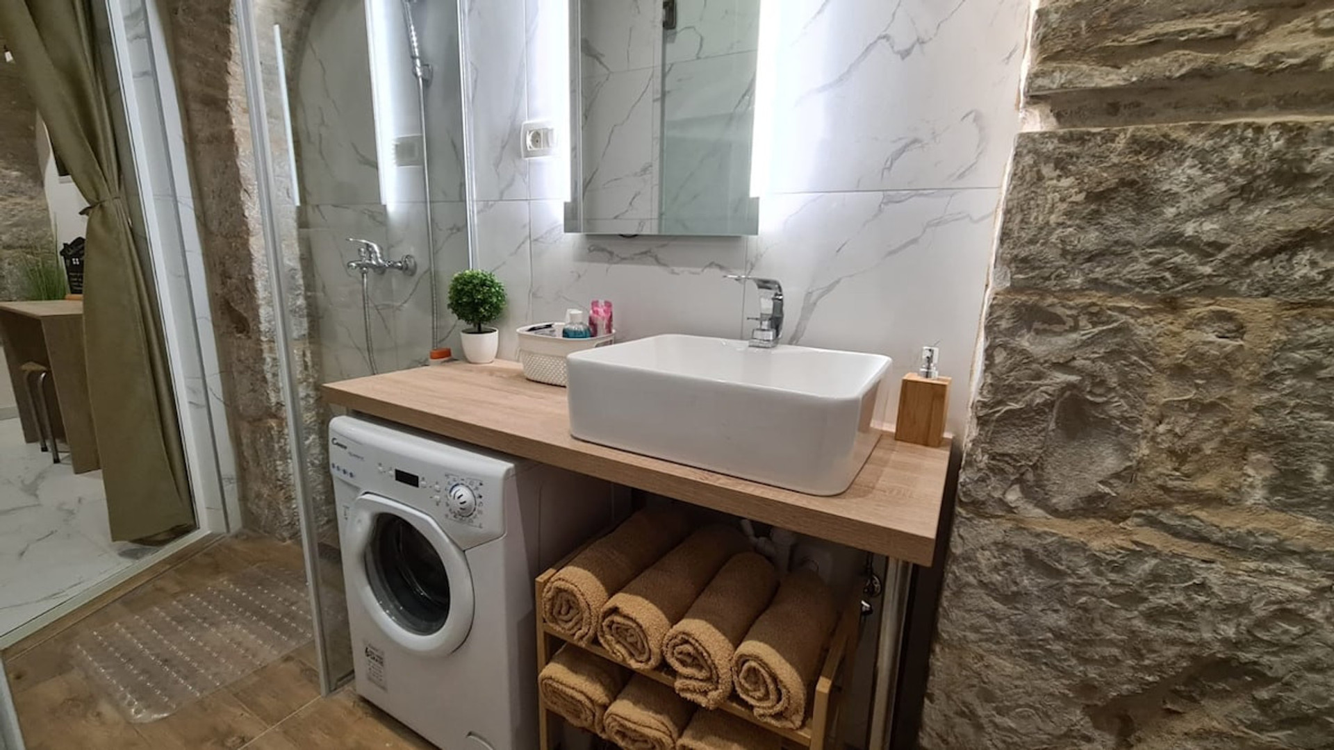 Bathroom featuring a shower and a washing machine. 