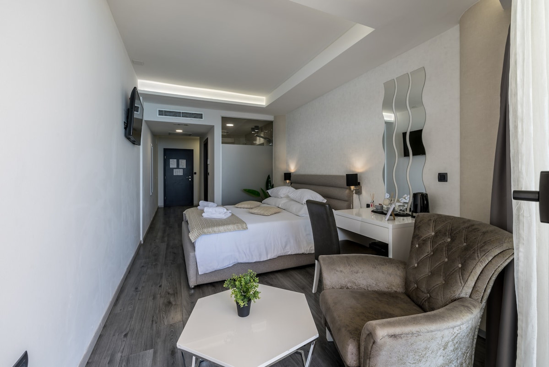 Spacious room with a bed, work desk, and comfortable seating.