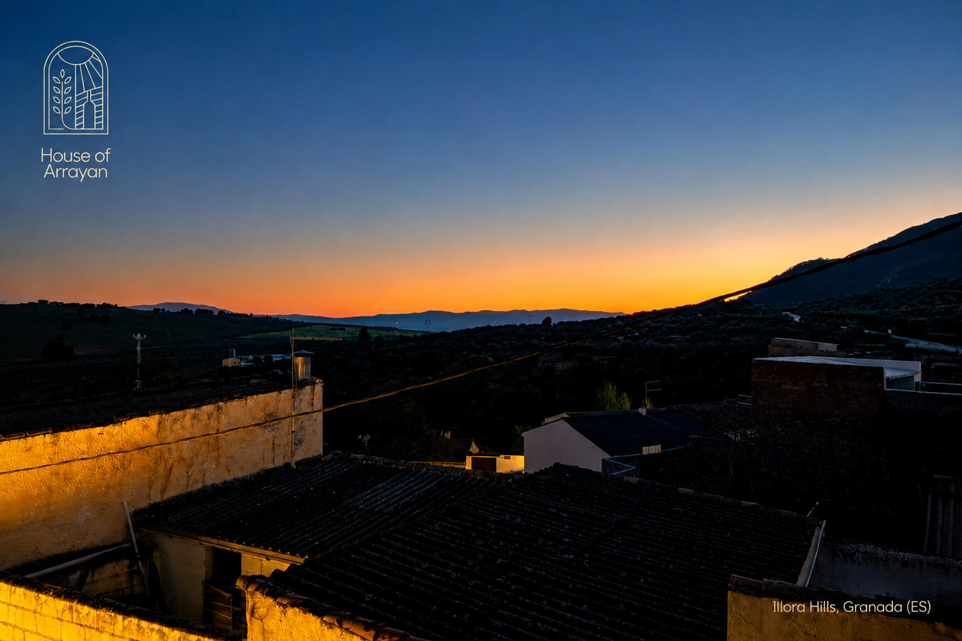 Sunset over rooftops and hills
