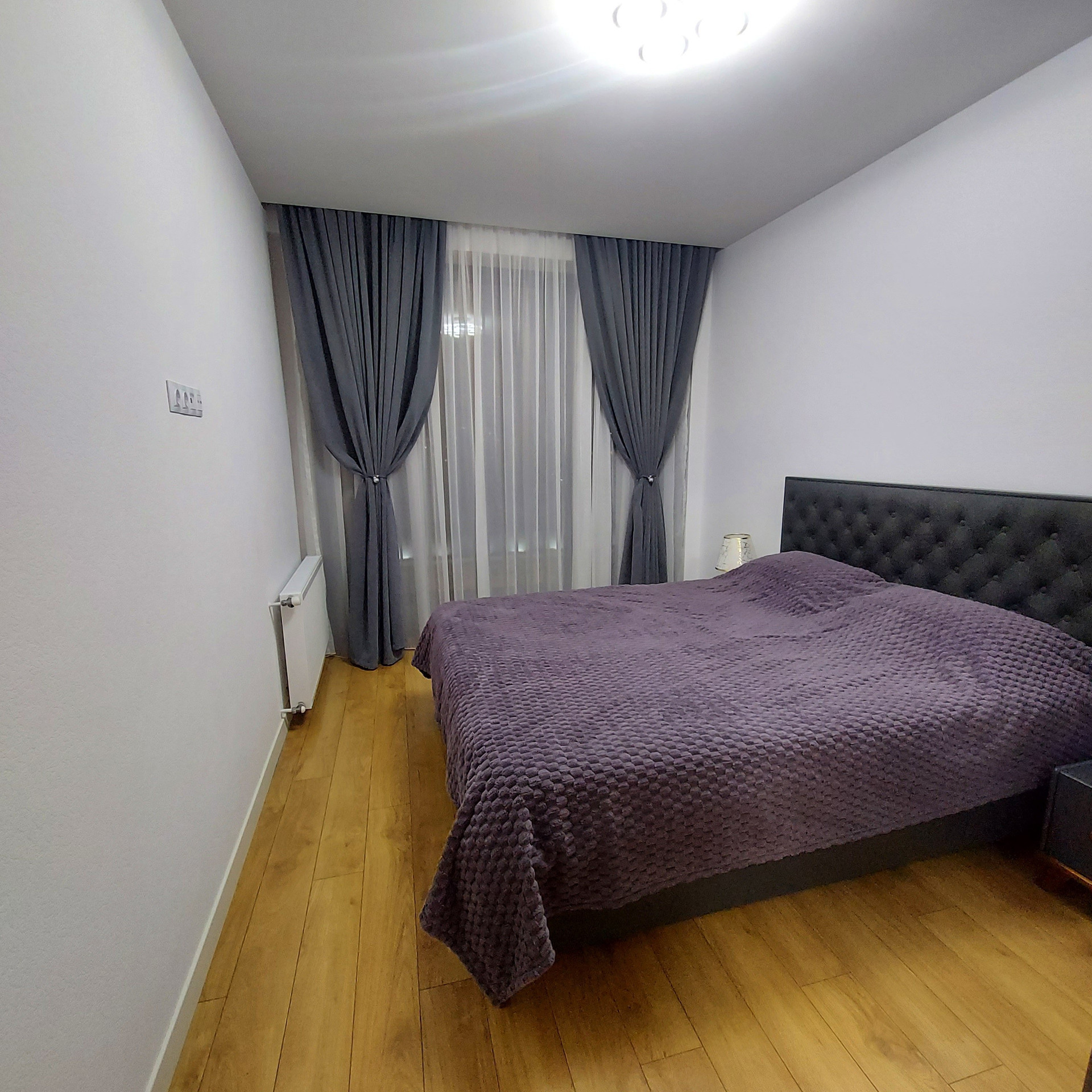 Bedroom with purple bedding and curtains