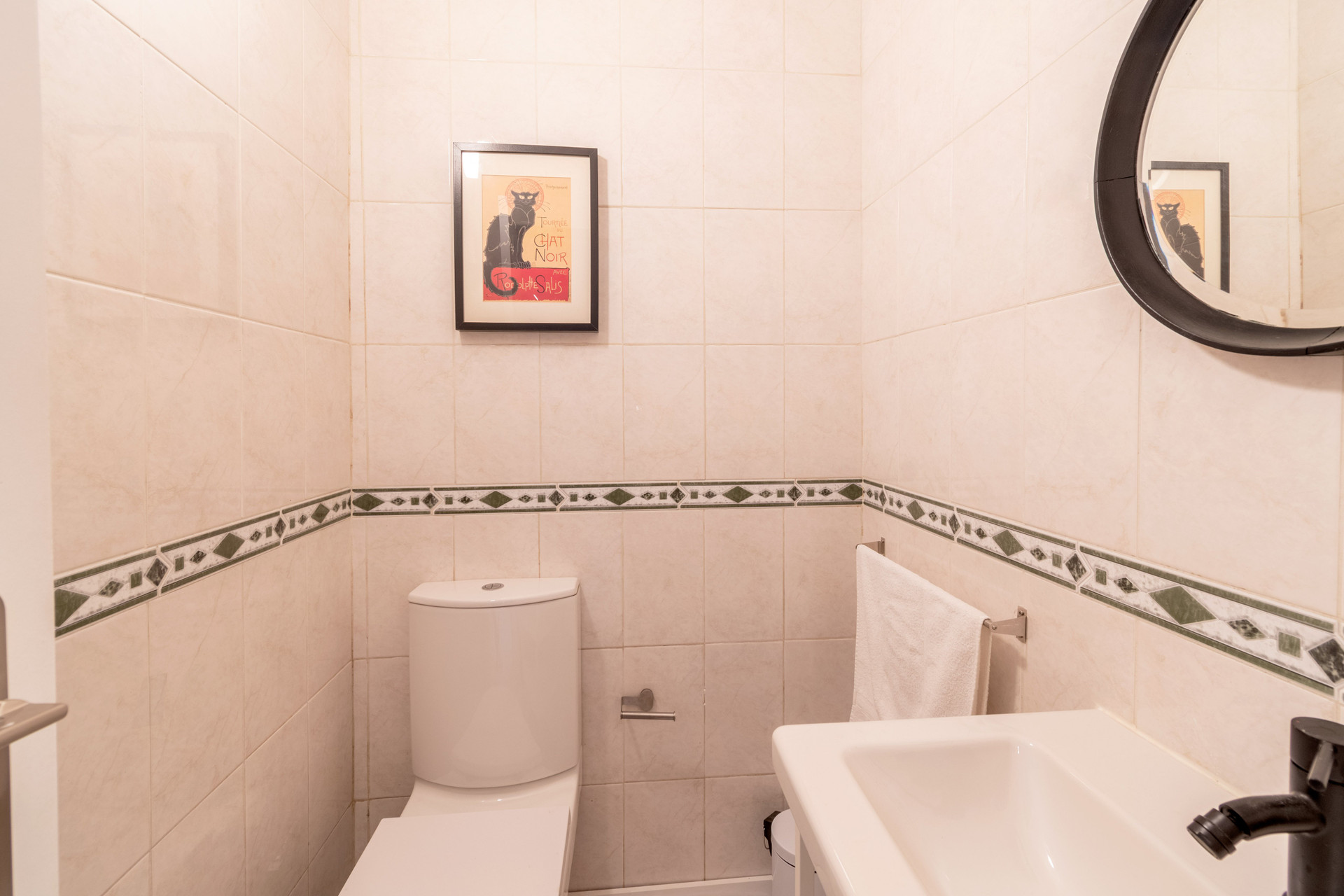 Bathroom with toilet and round mirror