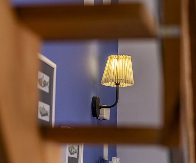 Wall sconce through stair railing