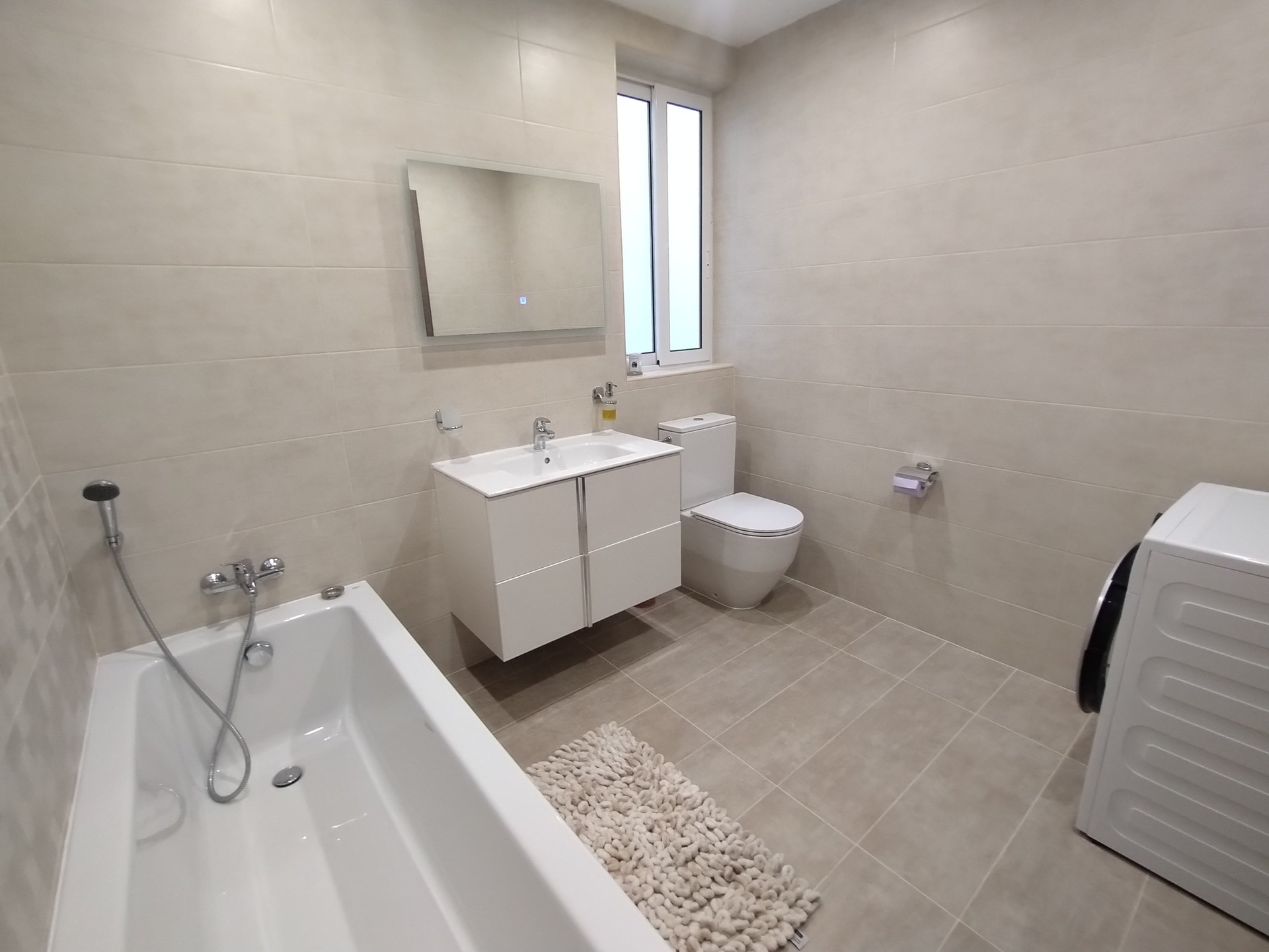 Bathroom with bathtub and washing machine