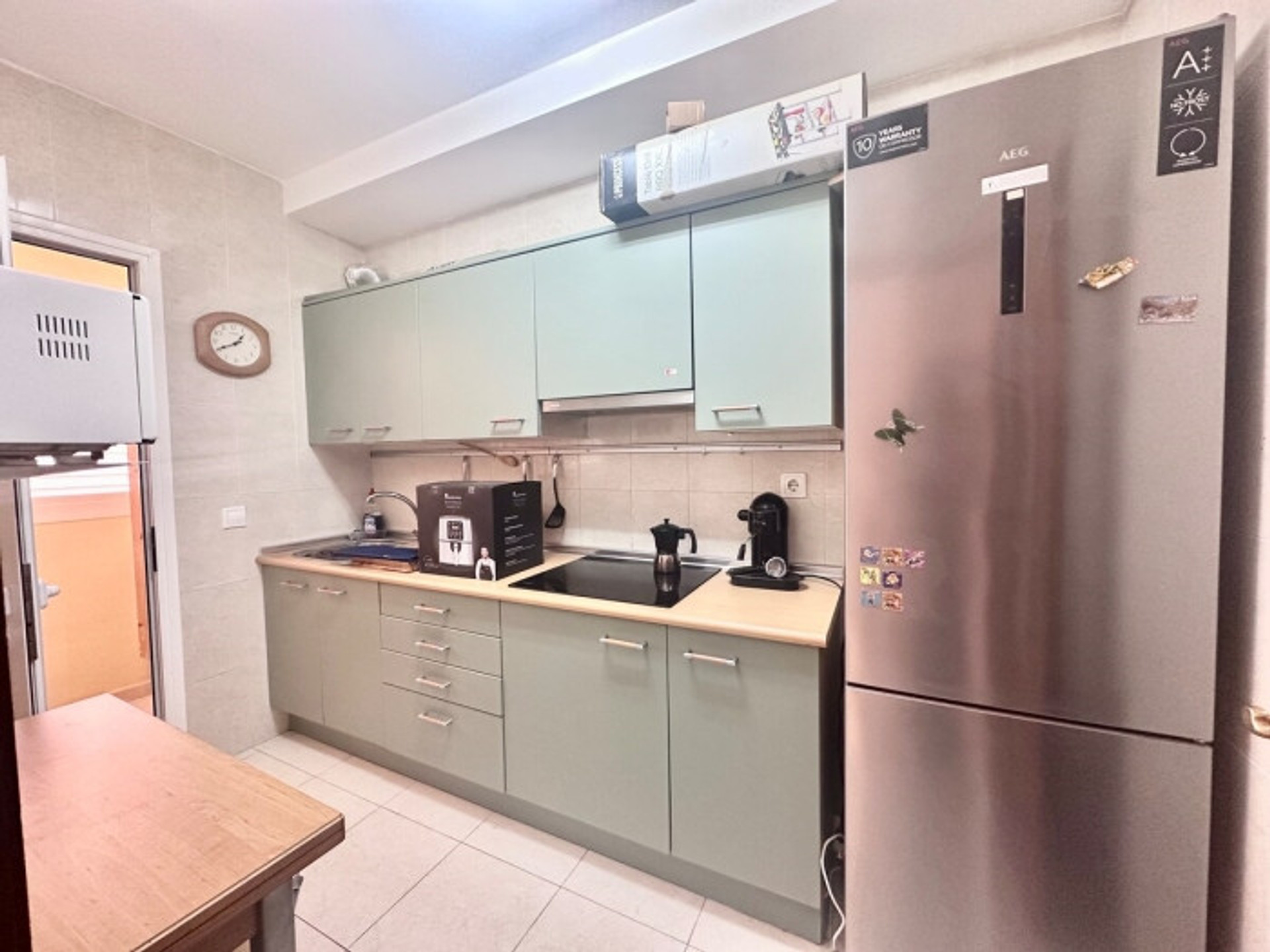 Kitchen with green cabinets and fridge