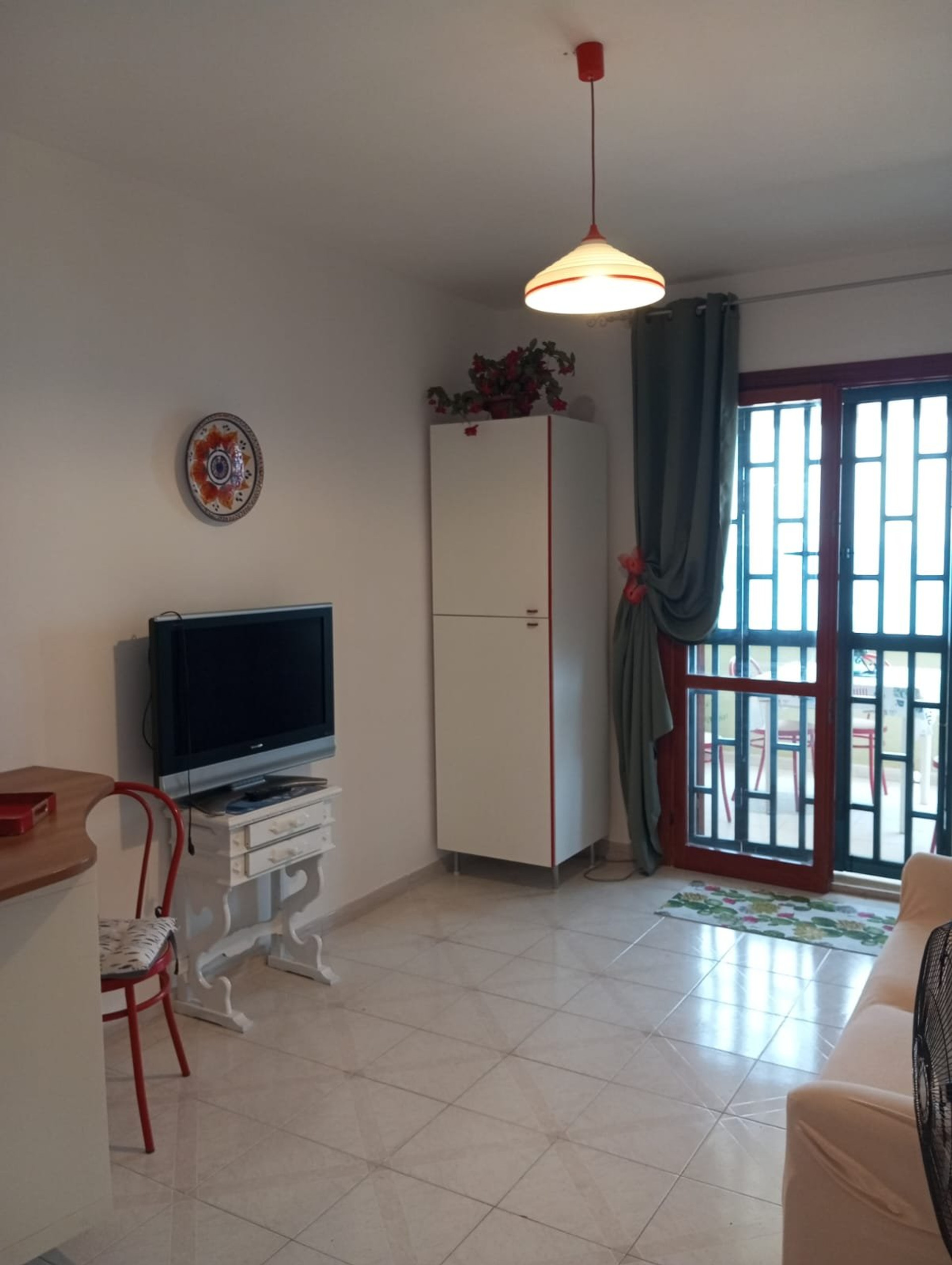 Living area with TV and balcony door